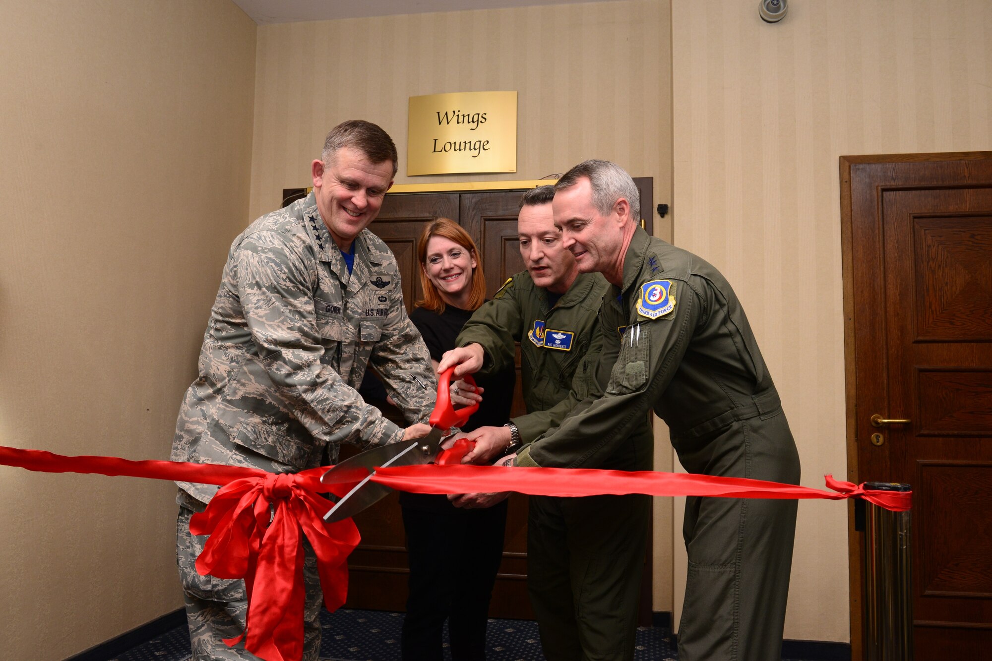 General Frank Gorenc, U.S. Air Forces in Europe and Air Forces Africa commander; Trish Dotson, Ramstein Officers’ Spouses Club president; Brig. Gen. Patrick X. Mordente, 86th Airlift Wing commander and Lt. Gen. Darryl Roberson, 3rd Air Force commander cut a ribbon to signify the grand opening of the newly renovated Wings Lounge in the Officers’ Club at Ramstein Air Base, Germany, Dec. 5, 2014. The new lounge boasts custom tabletops, recent mission photos and a snooker table, used to play the game Crud. (U.S. Air Force photo/Tech. Sgt. Travis Edwards)