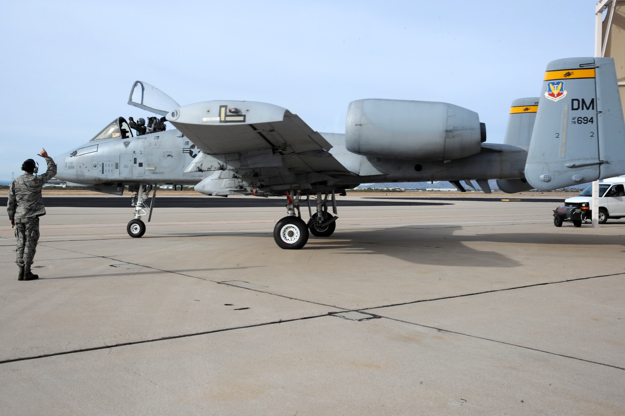 U.S. Air Force Senior Airman Charles Nicholls, 357th Aircraft Maintenance Unit dedicated crew chief, personally sends off Capt. Marcus Flagg, 358th Fighter Squadron A-10C Thunderbolt II instructor pilot, as he taxis in aircraft 694 at Davis-Monthan Air Force Base, Ariz., Dec. 5, 2014. Flagg conducted a functional check flight for the aircraft, which was grounded for two months after a landing gear malfunction, prior to it returning to the flight rotation. (U.S. Air Force photo by Staff Sgt. Courtney Richardson)