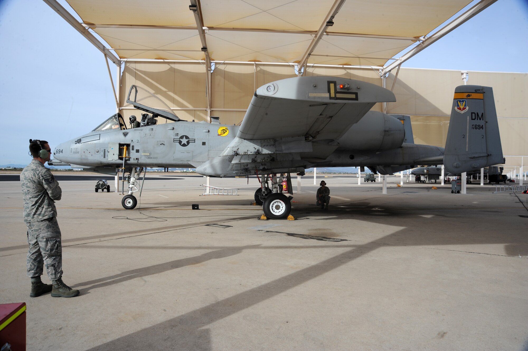 U.S. Air Force Staff Sgt. Justin Post, left, and Senior Airman Charles Nicholls, 357th Aircraft Maintenance Unit dedicated crew chiefs, wait as Capt. Marcus Flagg, 358th Fighter Squadron A-10C Thunderbolt II instructor pilot, completes his pre-flight inspection at Davis-Monthan Air Force Base, Ariz., Dec. 5, 2014. Flagg conducted a functional check flight for the aircraft, which was grounded for two months after a landing gear malfunction, prior to it returning to the flight rotation. (U.S. Air Force photo by Staff Sgt. Courtney Richardson)