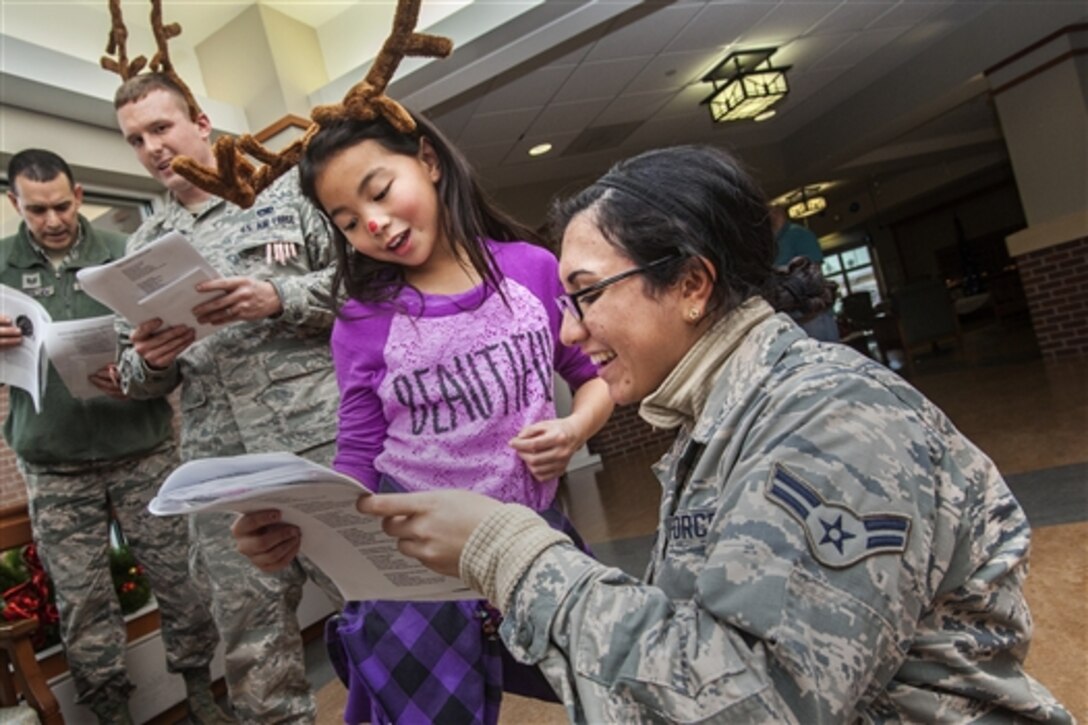 Air Force Tech. Sgt. Chris Goulden, left, Air Force Senior Airman Kris Gleason, center, and Air Force Airman 1st Class Erin Raggio, right, sing with 47 fourth graders from the Seaview Elementary School in Linwood, N.J., during the 14th Annual Holiday "Songfest" at the Veterans Memorial Home on Vineland, N.J., Dec. 9, 2014.  