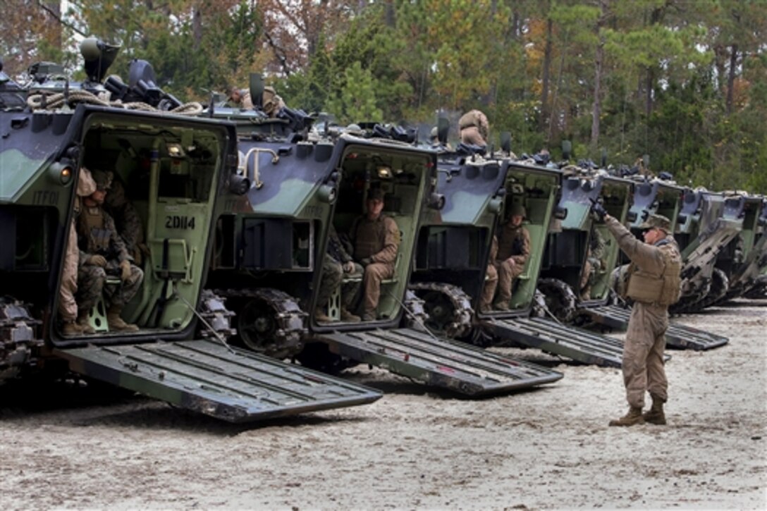 Marines close the ramps on amphibious assault vehicles as they depart the French Creek loading dock on Marine Corps Base Camp Lejeune, N.C., Dec. 2, 2014. 
 