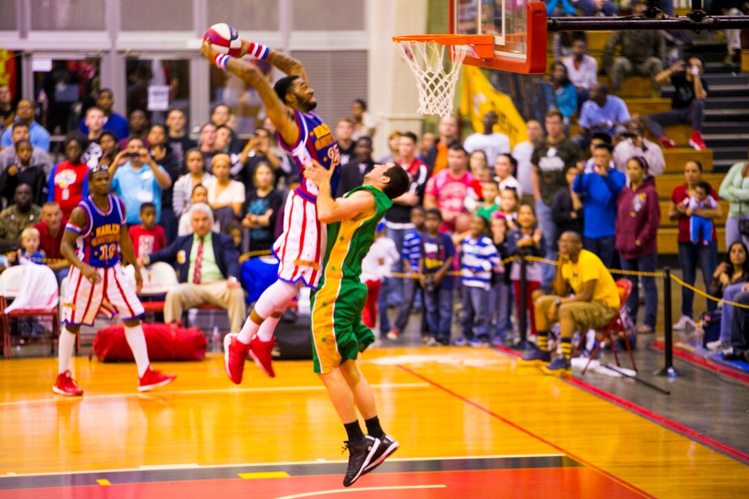 Harlem Globetrotters forward, Tydran ‘Crash’ Beaty, throws down the fanatic game winning dunk over a Washington Generals defender Dec. 9 at The Foster Field House on Camp Foster. The Harlem Globetrotters displayed their basketball artistry to service members and their families. The athletic basketball display was an opportunity for the Harlem Globetrotters to give a little taste of home to the service members serving overseas. The event was a part of the Harlem Globetrotters 13th military tour, in which the team travels overseas to U.S. military installations throughout Japan. The game was presented by Navy Entertainment, Leatherneck Tour and Marine Corps Community Services. 