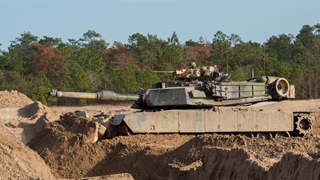 An M1A1 Abrams Tank uses a blade mounted onto the front in order to fill in a tank pit during breaching exercises aboard Marine Corps Base Camp Lejeune, North Carolina, December 8. Marines with 2nd Tank Battalion along with 2nd CEB worked together to conduct breaching exercises in which they provided support fire while Assault Breacher Vehicles eliminated tank pits and created a lane in which tanks may safely travel, aboard Camp Lejeune, December 8-10.