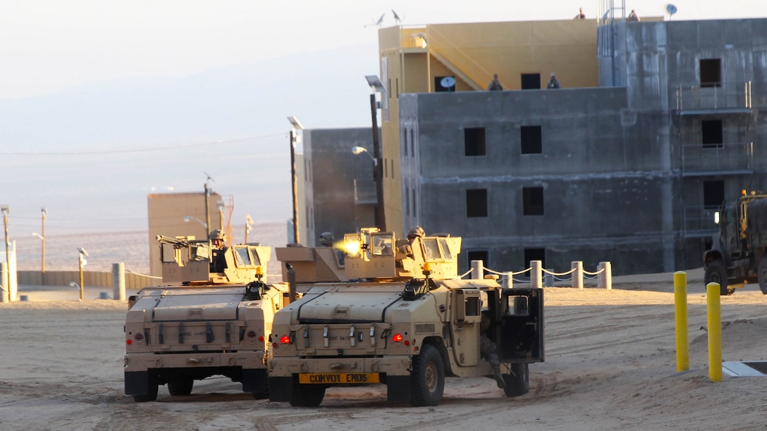 Marines with Truck Company, Combat Logistics Battalion 5, fire blanks on Marines acting as enemy soldiers in a mock enemy town while conducting convoy training during Exercise Steel Knight 2015 at Marine Corps Air Ground Combat Center Twentynine Palms, Calif., Dec. 5, 2014. The exercise gave the Marines the opportunity to refine and rehearse essential combat skills needed in a combat environment. Steel Knight is an annual exercise that includes elements from the entire I Marine Expeditionary Force. The exercise focuses on conventional operations and provides realistic training that prepares Marine for overseas operations. 