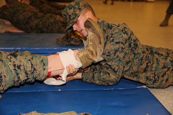 A recruit of Golf Company, 2nd Recruit Training Battalion, gives a test dummy proper combat care for a simulated leg injury at Marine Corps Recruit Depot San Diego, Calif., Dec. 2. The practical application test is a requirement that all recruits must pass before becoming Marines.