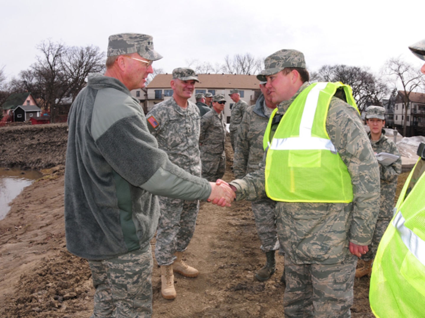 Gen. Craig R. McKinley, chief of the National Guard Bureau, shakes hands
with Staff Sgt. Adam Kapaun of the North Dakota Air National Guard's 119th Wing while walking dike patrol near the Oak Grove Lutheran School on March 22, 2010. McKinley spent the day in Fargo, N.D., visiting the Guardsmen currently on flood duty in the state.