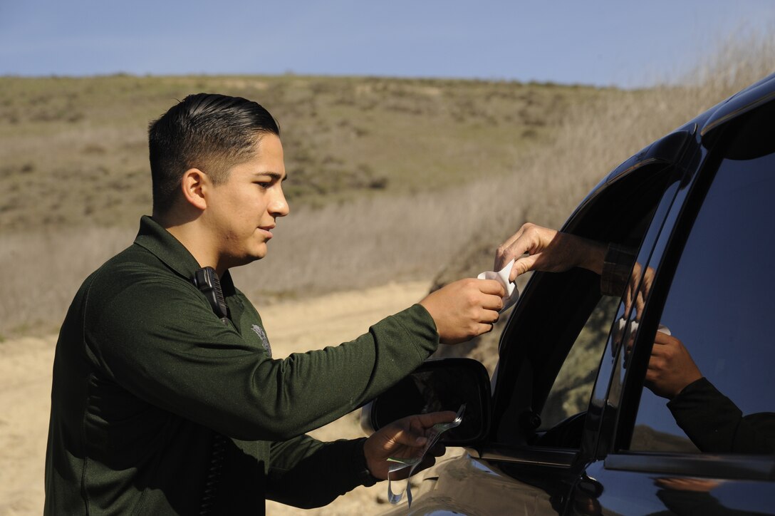 Staff Sgt. Michael Vera checks a hunter’s credentials, Dec. 9, 2014, at Vandenberg Air Force Base, Calif. The 10-man team of conservation officers covers the area on four-wheeled vehicles and horses, ensuring security and safety for the base’s human and animal residents. Vera is a 30th Security Forces Squadron conservation officer. (U.S. Air Force photo/Airman 1st Class Ian Dudley) 