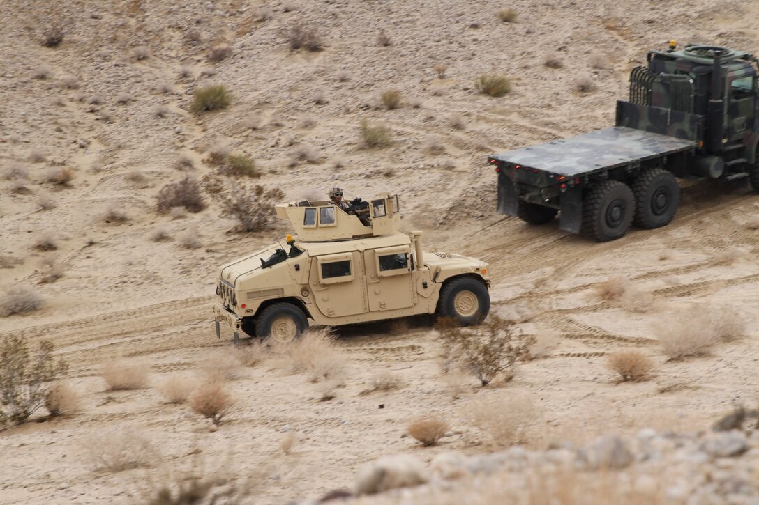 A Marine with Truck Company, Combat Logistics Battalion 5, scans the hills for Marines acting as enemy soldiers during convoy training in support of Exercise Steel Knight 2015 at Marine Corps Air Ground Combat Center Twentynine Palms, Calif., Dec. 4, 2014. The exercise gave the Marines the opportunity to refine and rehearse essential combat skills needed in a combat environment. Steel Knight is an annual exercise that includes elements from the entire I Marine Expeditionary Force. The exercise focuses on conventional operations and provides realistic training that prepares Marines for overseas operations. (U.S. Marine Corps photo by Cpl. Christopher J. Moore/Released)