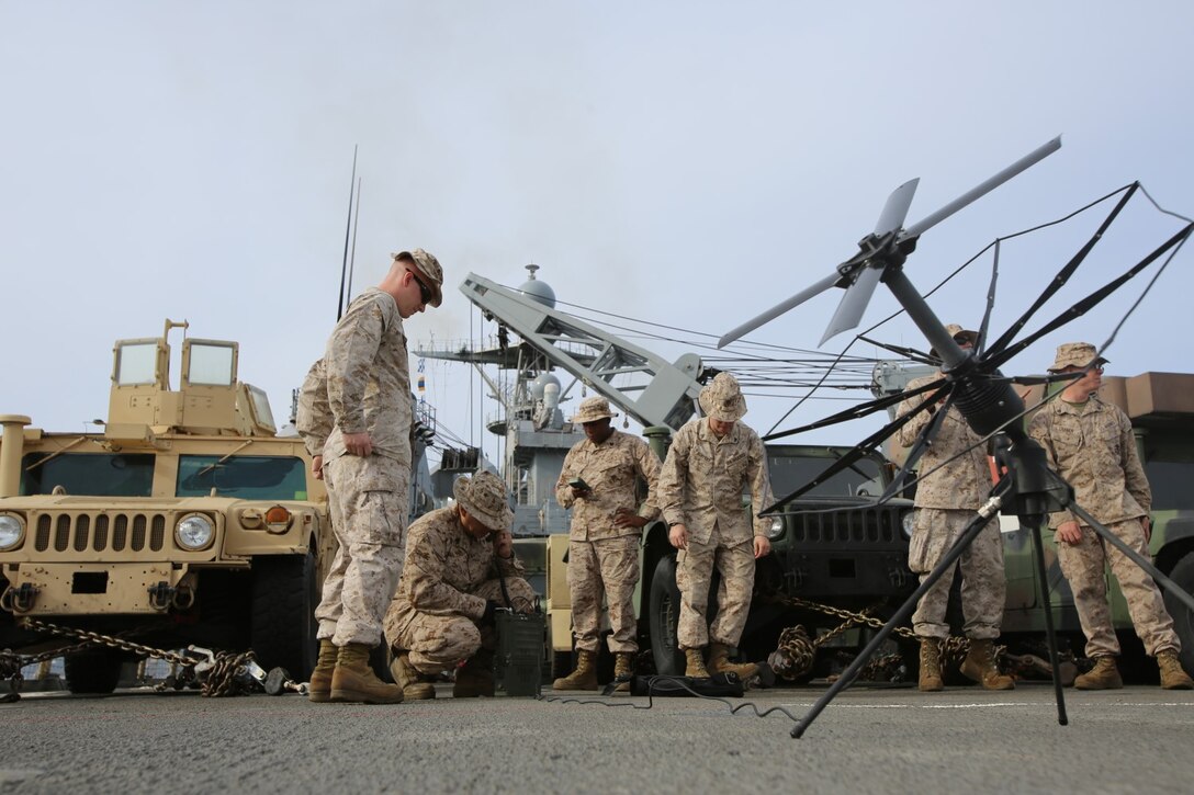 Radio operators with Headquarters and Service Company, 3rd Assault Amphibian Battalion, set up a satellite to establish a communication network during exercise Steel Knight aboard USS Rushmore, Dec. 8, 2014. Steel Knight is an annual exercise that allows 1st Marine Division to test and refine its command and control capabilities by acting as the headquarters element for forward-deployed Marine Air Ground Task Forces.