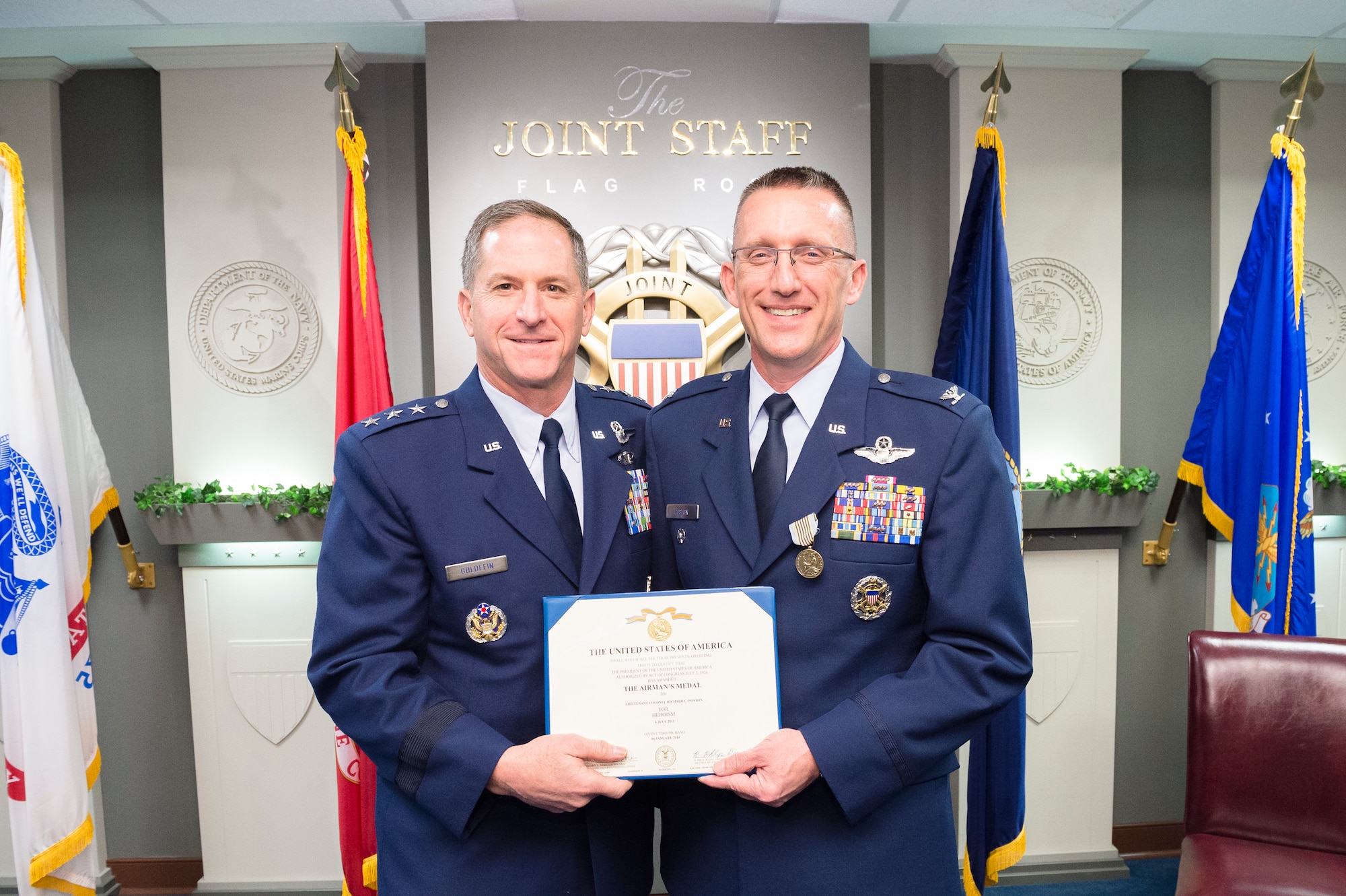 Lt. Gen. David L. Goldfein and Col. Richard Poston pose for a photo Dec. 10, 2014, during Poston’s Airman’s Medal ceremony held at the Pentagon in Washington D.C. Poston was recognized for his heroic actions on July 6, 2013, when he saved a young female from drowning in the Potomac River. Goldfein is the director of the Joint Staff and Poston is the assistant deputy director for political military affairs, strategic plans and policy, J-5 DD-Africa. (Defense Department photo/ U.S. Army Staff Sgt. Sean K. Harp)