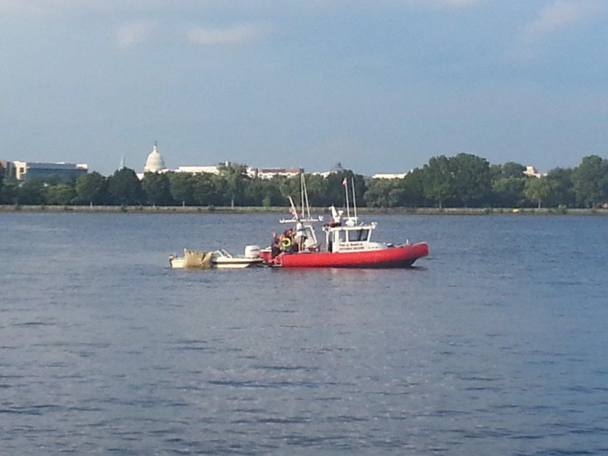 A boat pulls out submerged vessel from the Potomac River in Washington D.C. This photo was captured a couple days after Col. Richard Poston helped save a young girl from drowning. She, along with the other four members, was aboard the vessel when it went under. (Courtesy photo/U.S. Air Force Col. Richard Poston)