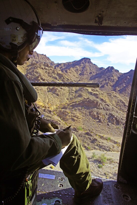 Lance Cpl. Kevin Herrera, a UH-1Y helicopter crew chief with Marine Light Attack Helicopter Squadron 267, based out of Marine Corps Base Camp Pendleton, Calif., takes notes during an expeditionary evolution over the Chocolate Mountains Aerial Gunnery Range on Marine Corps Air Station Yuma, Ariz., Dec. 9, 2014.