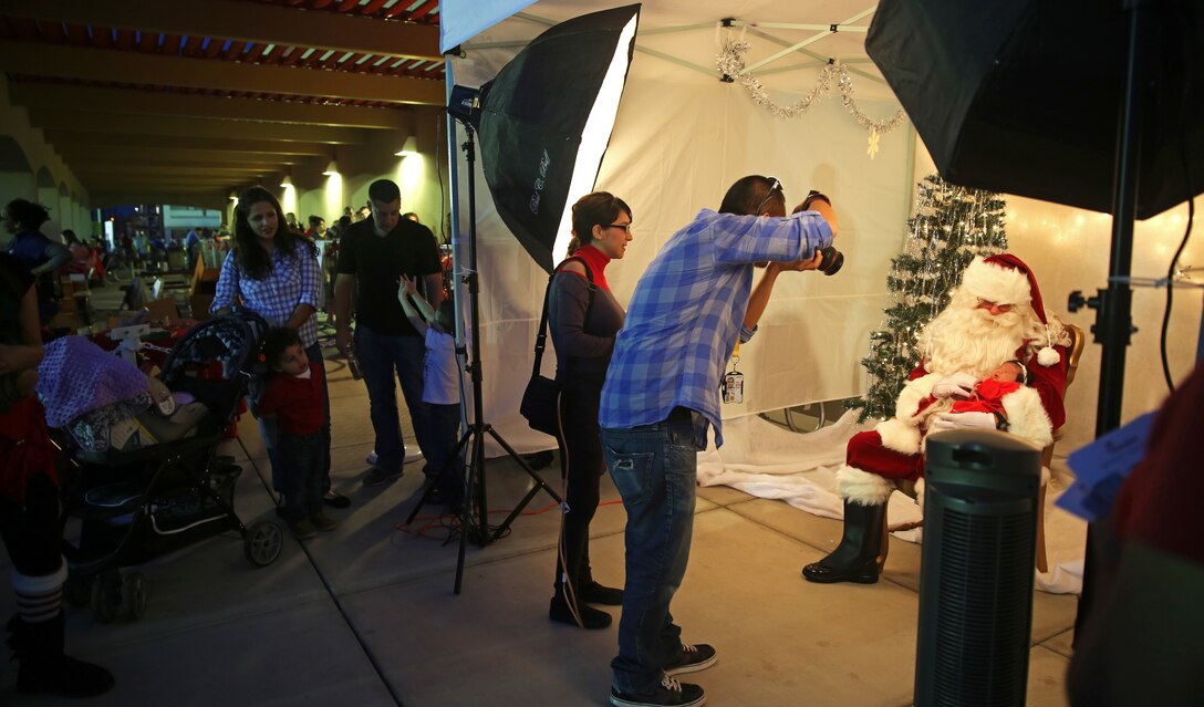 Service members and their families line up for a photo with Santa Claus at Marine Corps Air Station Yuma, Ariz., Friday, Dec. 5, 2014. The event, hosted by Marine Corps Community Services, also provided free food samples, a Christmas tree lighting ceremony, games, prize raffles and live music.