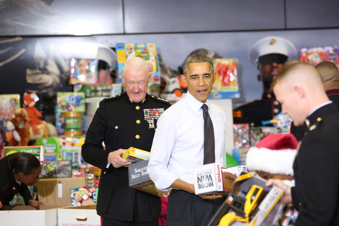 President Barack Obama is assisted by Lt. Gen. Richard P. Mills, commander of Marine Forces Reserve, and other Marines, to sort toys during a Toys for Tots event at Joint Base Anacostia-Bolling, Dec. 10, 2014. The Toys for Tots drive is a program developed by Marine Forces Reserve to provide needy children with toys for Christmas. 