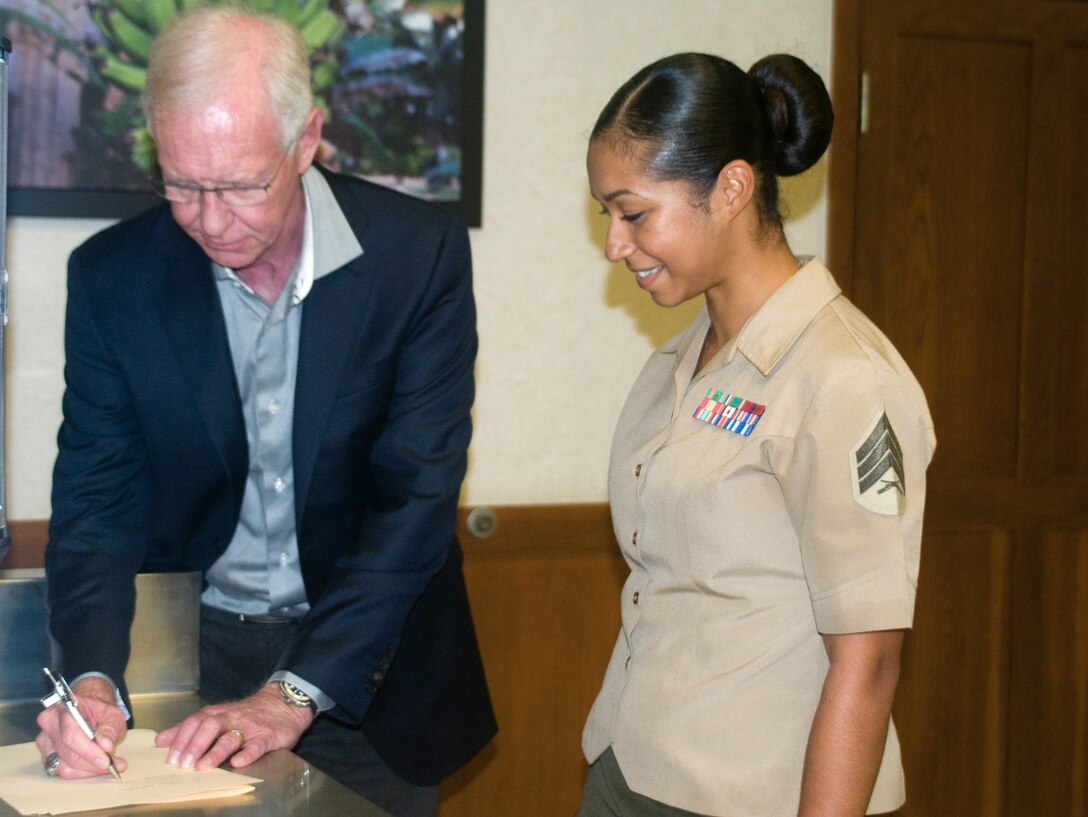 Former airline pilot Chesley “Sully” Sullenberger signs an autograph for Sgt. Corraine Cotton, an aviation maintenance analyst from Marine Light Attack Helicopter Squadron 367, Dec. 5, 2014. (U.S. Marine Corps photo by Christine Cabalo/Released)