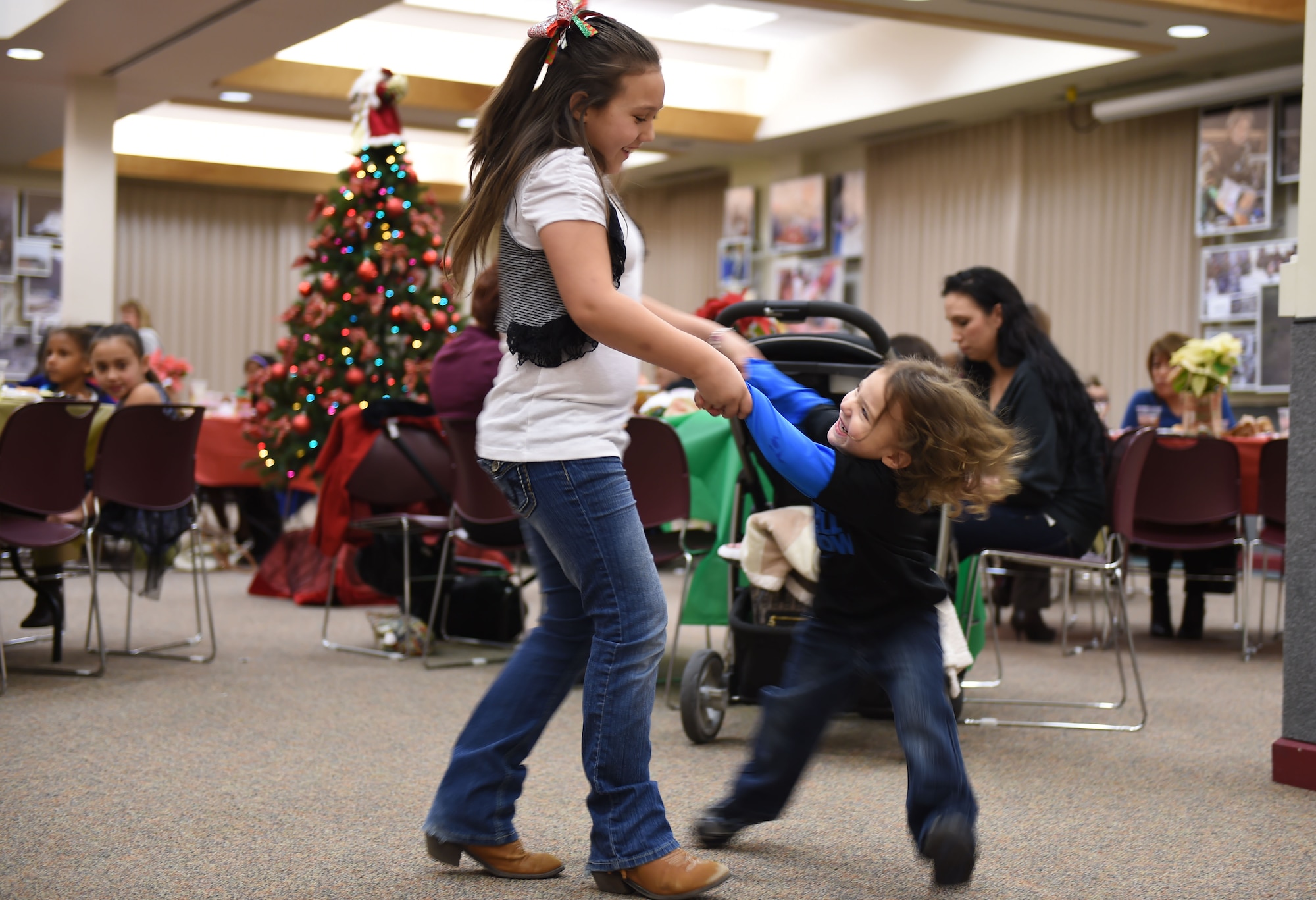 Children dance to Christmas songs performed by a live band at the Hearts Apart Family Holiday Dinner event Dec. 11, 2014, at the 140th Wing dining facility on base. The band took the children’s’ requests to play their favorite Christmas tune and played for them. (U.S. Air Force photo by Airman 1st Class Emily E. Amyotte/Released)