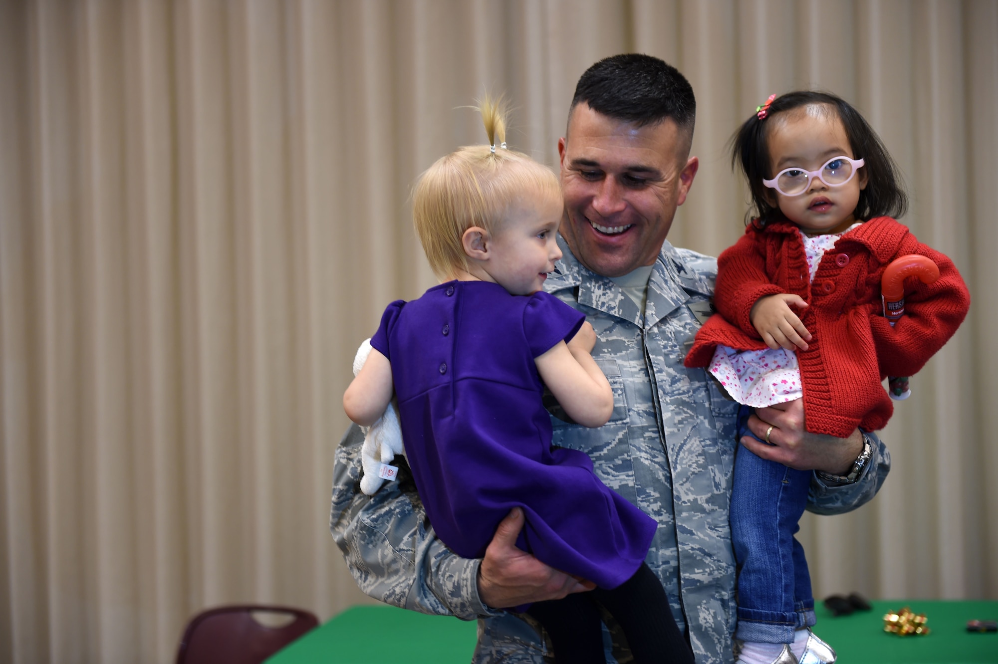 Col. John Wagner, 460th Space Wing commander, greets two children at the Hearts Apart Family Holiday Dinner event Dec. 11, 2014, at the 140th Wing dining facility on base. At the event, the families received stockings filled with presents and participated in raffle drawings throughout the night. (U.S. Air Force photo by Airman 1st Class Emily E. Amyotte/Released)