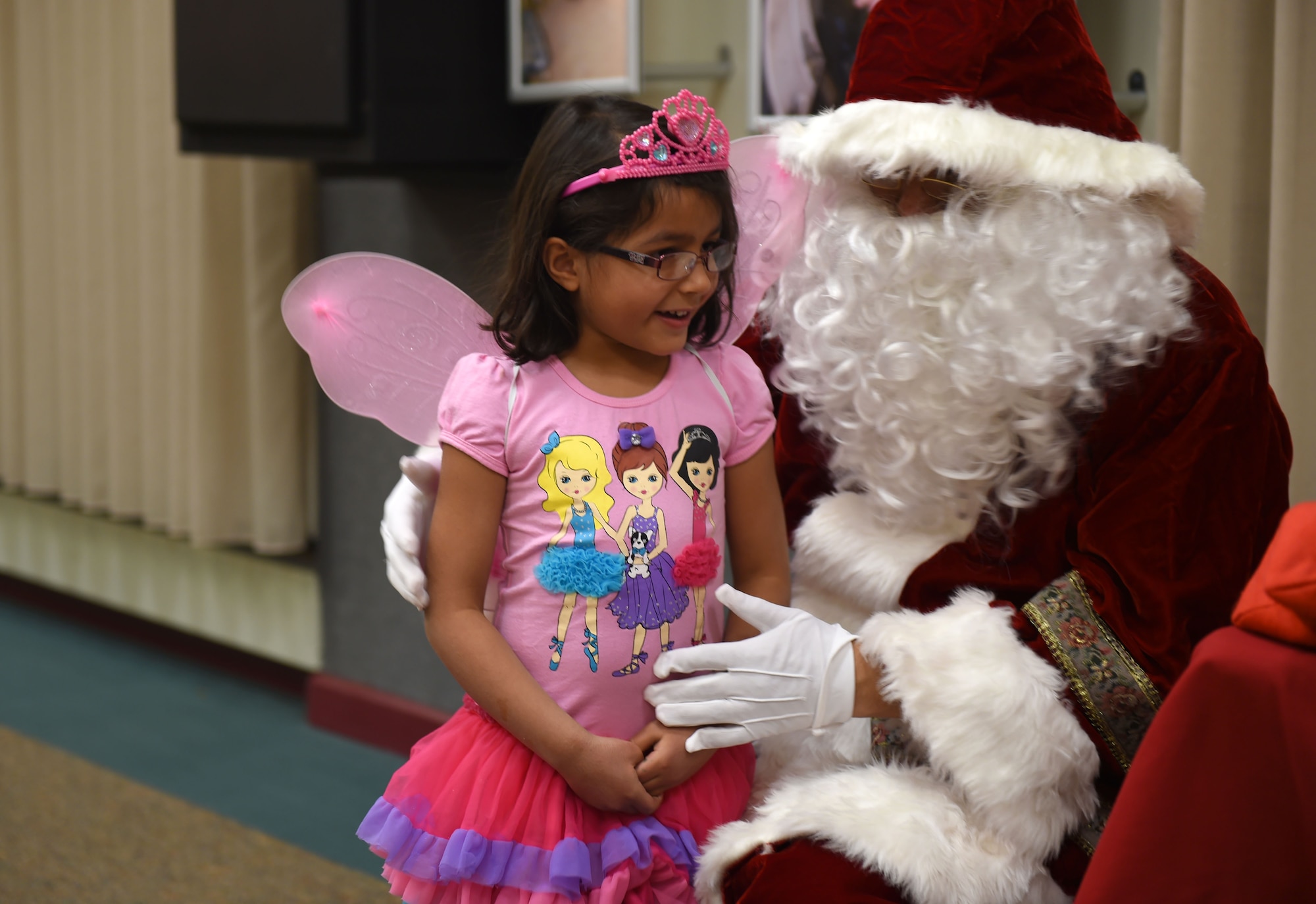 A Team Buckley child visits Santa Claus during the Hearts Apart Family Holiday Dinner event Dec. 11, 2014, at the 140th Wing dining facility on base. At the event, the families received stockings filled with presents and participated in raffle drawings throughout the night. (U.S. Air Force photo by Airman 1st Class Emily E. Amyotte/Released)