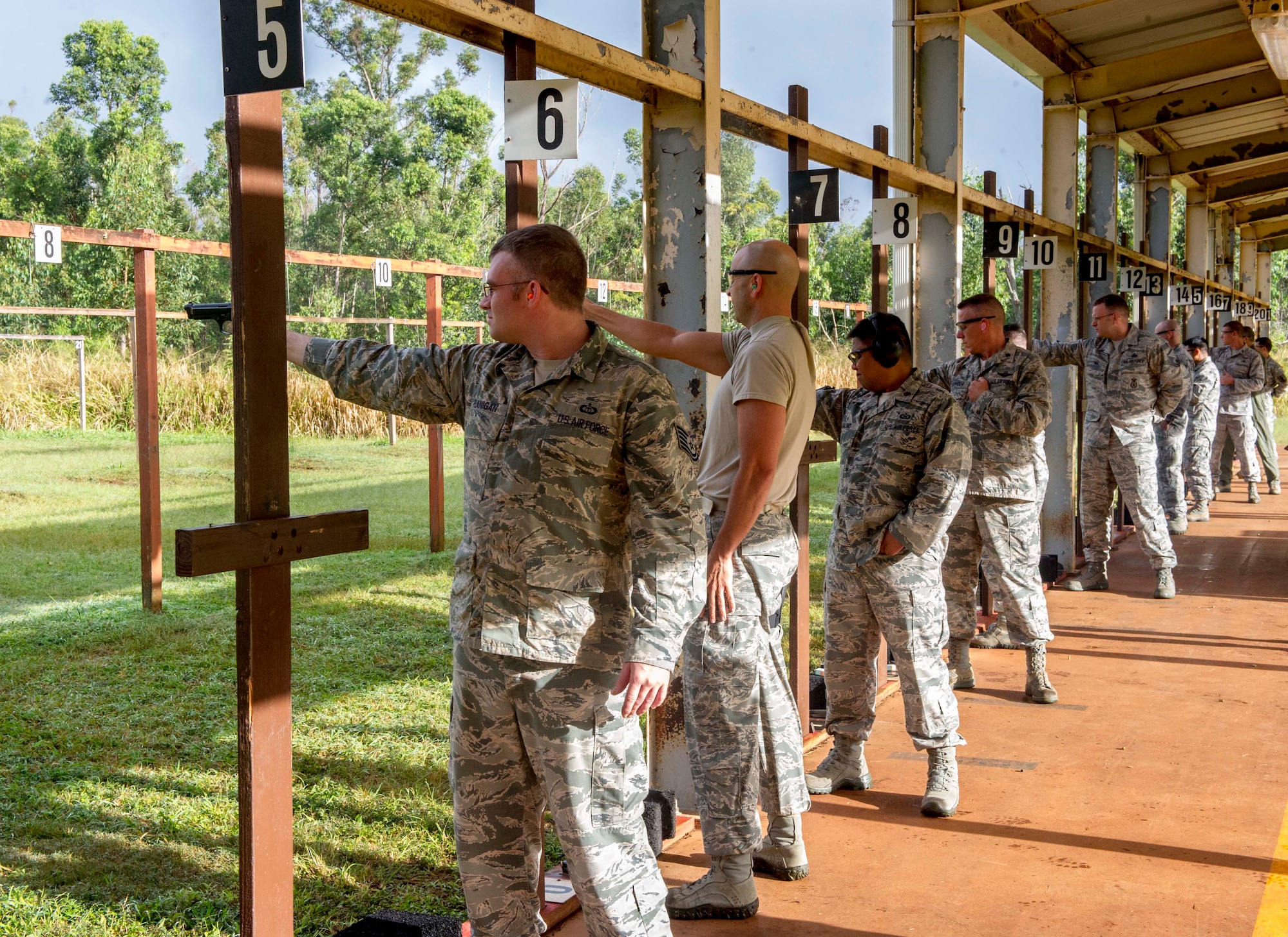 Participants in the 647th Security Forces Squadron Combat Arms Training and Maintenance Flight elementary level Excellence in Competition Pistol Match prepare to fire their weapons at the Air Force shooting range on Schofield Barracks, Hawaii, Dec. 11, 2014. For the competition, the participants were asked to fire a 9MM one handed and two handed with variations for the best overall score. The top 10 percent of the participants walked away with bragging rights, and the authorization to wear the Elementary Excellence in Competition Pistol Badge on their ribbon racks. (U.S. Air Force photo by Tech. Sgt. Terri Paden/RELEASED)