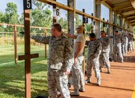 Participants in the 647th Security Forces Squadron Combat Arms Training and Maintenance Flight elementary level Excellence in Competition Pistol Match prepare to fire their weapons at the Air Force shooting range on Schofield Barracks, Hawaii, Dec. 11, 2014. For the competition, the participants were asked to fire a 9MM one handed and two handed with variations for the best overall score. The top 10 percent of the participants walked away with bragging rights, and the authorization to wear the Elementary Excellence in Competition Pistol Badge on their ribbon racks. (U.S. Air Force photo by Tech. Sgt. Terri Paden/RELEASED)