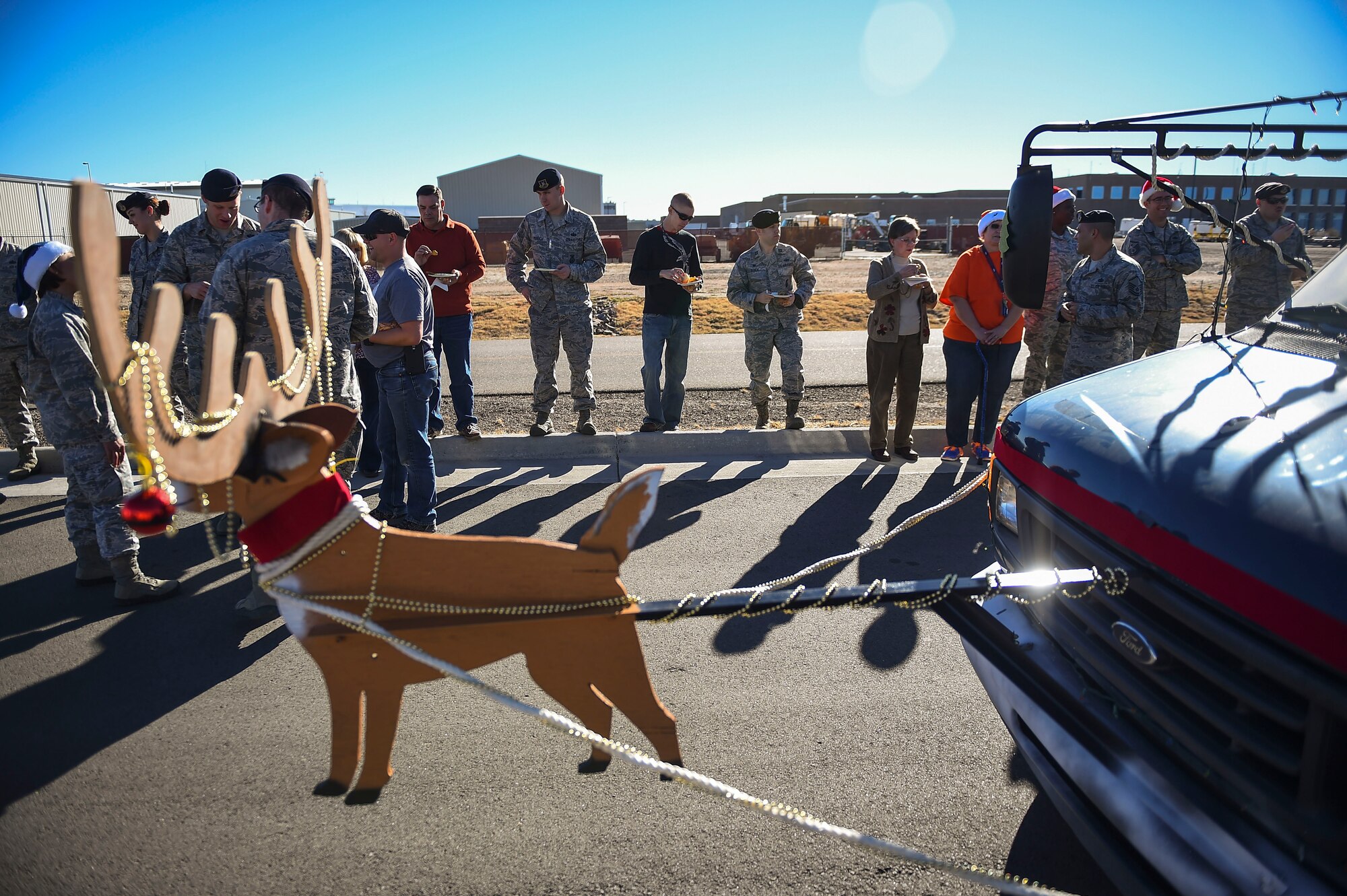 Members of the 460th Security Forces Squadron partake in food from the 460th Mission Support Group’s holiday party bus Dec. 11, 2014, on Buckley Air Force Base, Colo. During their route, the holiday party bus crew made stops at 19 support group work areas while distributing food and holiday greetings. Some of the 460th MSG agencies the bus visited were the fire department, outdoor recreation and child development centers and security forces, civil engineer, and force support squadrons. (U.S. Air Force photo by Senior Airman Riley Johnson/Released)