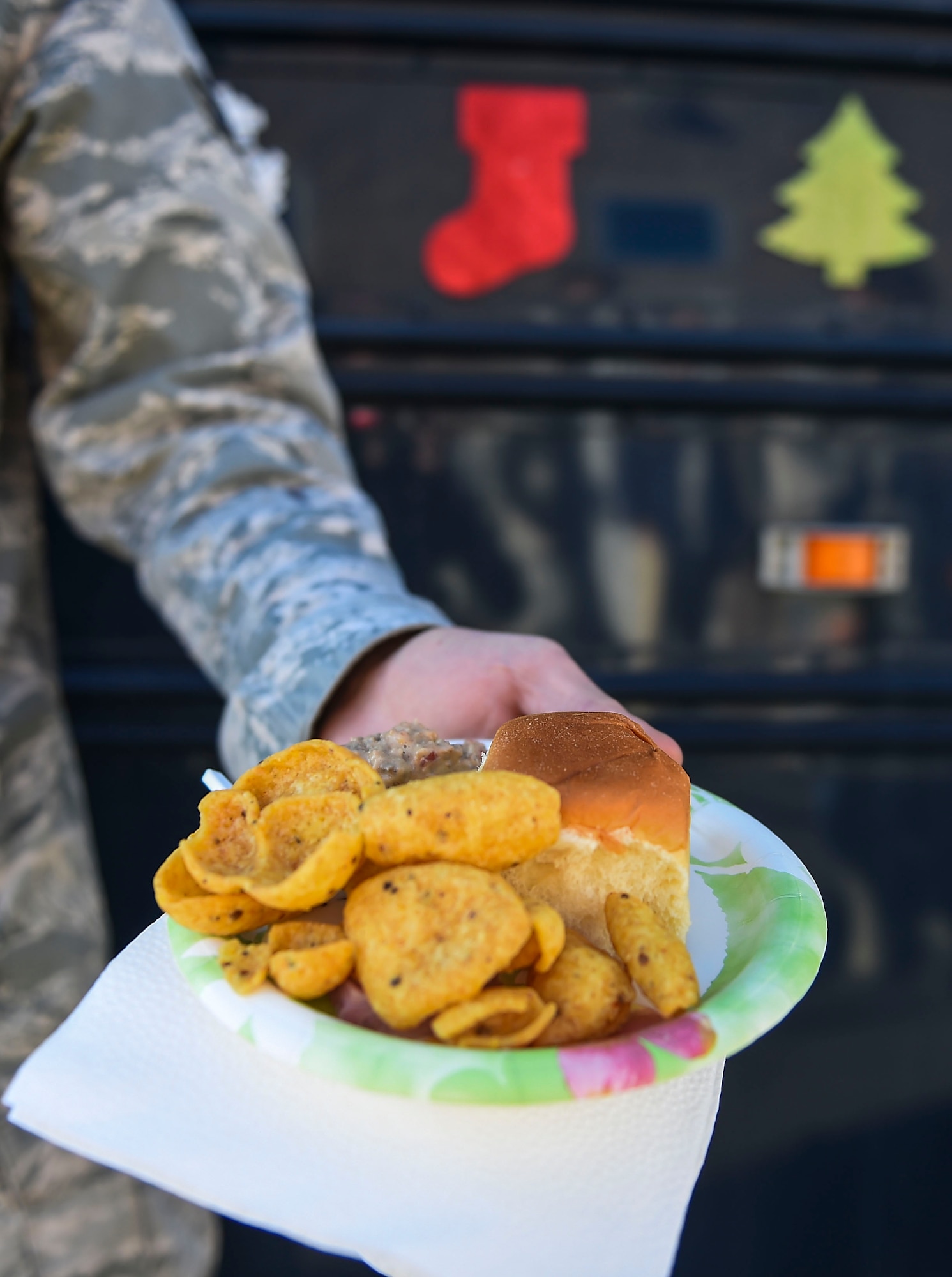 Senior Airman Jayce Yeager, 460th Civil Engineer Squadron, grabs a plate of food from the 460th Mission Support Group’s holiday party bus Dec. 11, 2014, on Buckley Air Force Base, Colo. During their route, the holiday party bus crew made stops at 19 support group work areas while distributing food and holiday greetings. Some of the 460th MSG agencies the bus visited were the fire department, outdoor recreation and child development centers and security forces, civil engineer, and force support squadrons. (U.S. Air Force photo by Senior Airman Riley Johnson/Released)