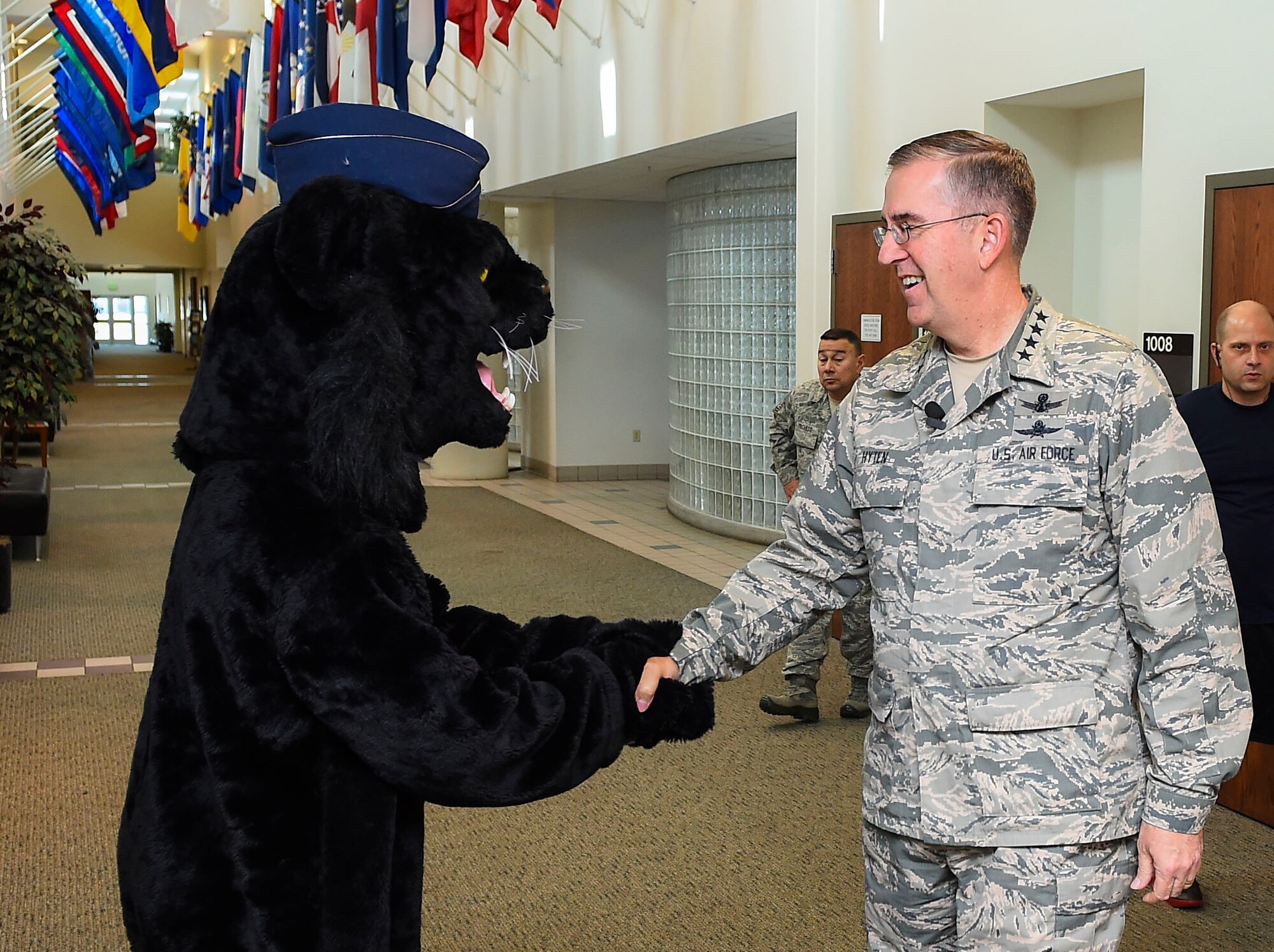 Buck Lee, 460th Space Wing mascot, left, shakes hands with General John E. Hyten, Commander of Air Force Space Command, Dec. 10, 2014, in the fitness center on Buckley Air Force Base, Colo. During General Hyten’s first visit to Buckley after assuming AFSPC command Aug 2014, he received a mission brief, toured the 460th Operations Group Mission Control Station and spoke with Airmen at a commander’s call. AFSPC provides space and cyberspace capabilities for the joint force and the nation, and the 460th SW is one of several units in Colorado and around the world that supports AFSPC’s mission. (U.S. Air Force photo by Senior Airman Riley Johnson/Released)