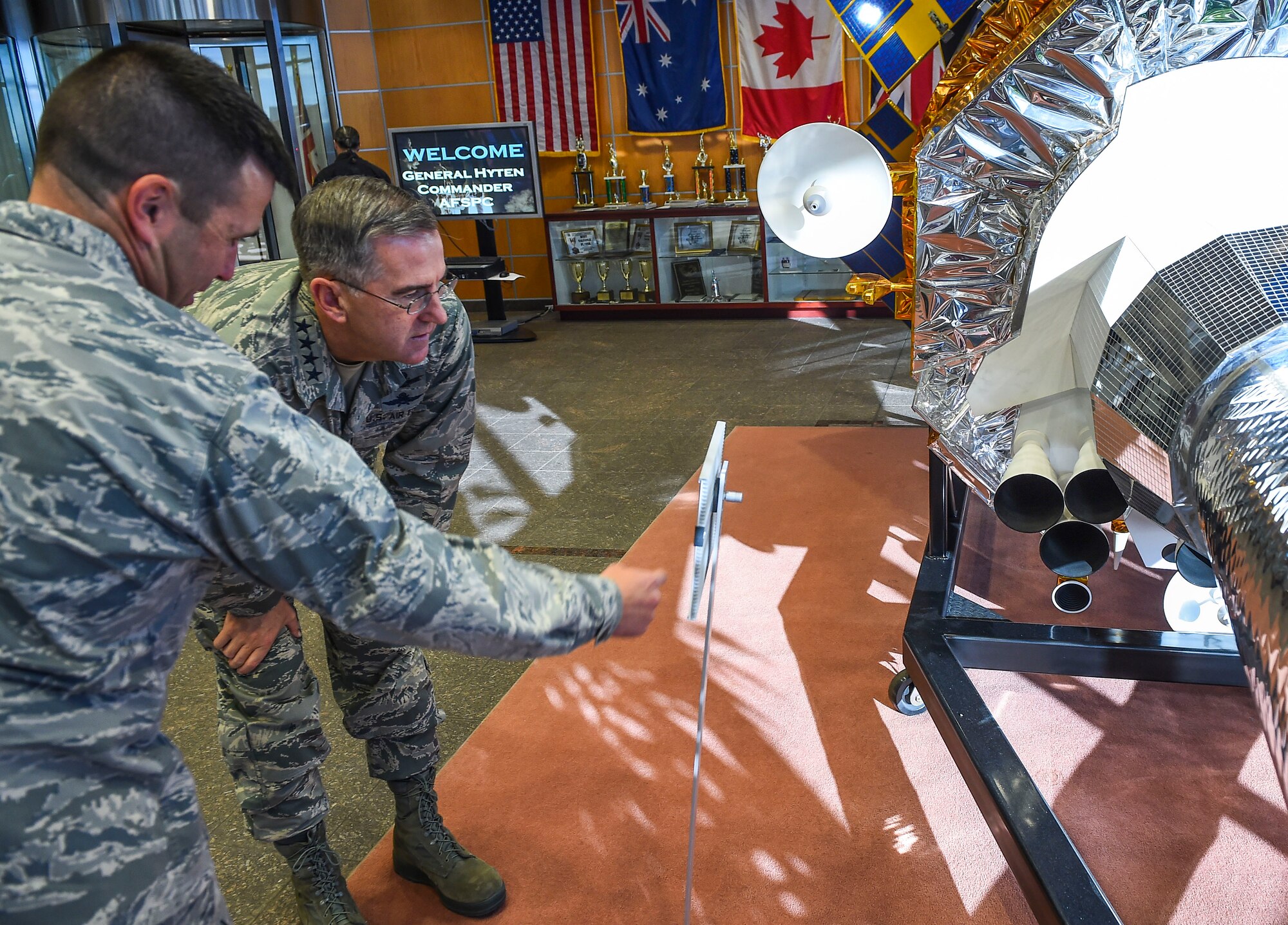 Col. John Wagner, 460th Space Wing commander, left, shows General John E. Hyten, Commander of Air Force Space Command, a satellite display model Dec. 10, 2014, in the 460th Operations Group Mission Control Station on Buckley Air Force Base, Colo. During General Hyten’s first visit to Buckley after assuming AFSPC command Aug 2014, he received a mission brief, toured the mission control station and spoke with Airmen at a commander’s call. AFSPC provides space and cyberspace capabilities for the joint force and the nation, and the 460th SW is one of several units in Colorado and around the world that supports AFSPC’s mission. (U.S. Air Force photo by Senior Airman Riley Johnson/Released)