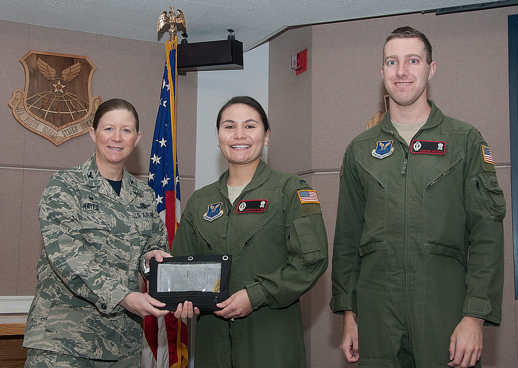 141205-F-GZ967-001 1st Lts. Kristen Clark and Andre Walter, 320th Missile Squadron missileers, pose with Col. Tracey Hayes, 90th Missile Wing commander, as she presents them the keys to a new government-owned vehicle Dec. 5, 2014, in the 90th Operations Group pre-departure room, F.E. Warren Air Force Base, Wyo. Warren received a total of 26 new trucks as part of the Force Improvement Program’s initiative to provide substantial changes within the ICBM missions.  (U.S. Air Force photo/Airman 1st Class Brandon Valle)