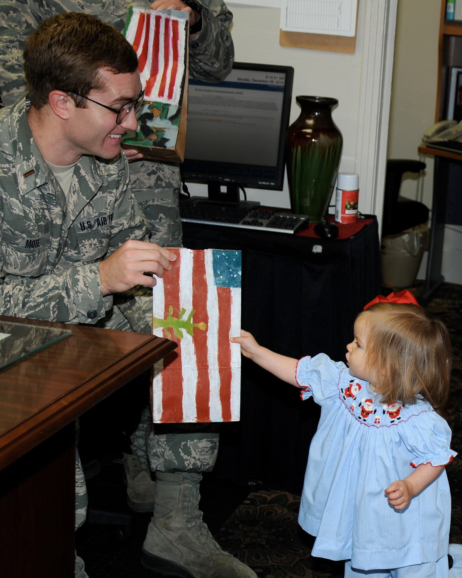 Tharin Brown, daughter of Capt. Adam Brown, hands a bag of cookies to 2nd Lt. Joshua Mote, 14th Student Squadron, during the Columbus Spouse’s Club Cookie Drive at Columbus Air Force Base Dec. 8. Donations and other support were provided by Columbus community members and local businesses as well as base community members which helped make the event successful, providing more than 700 bags of cookies to unaccompanied Airman. (U.S. Air Force photo/Sharon Ybarra)