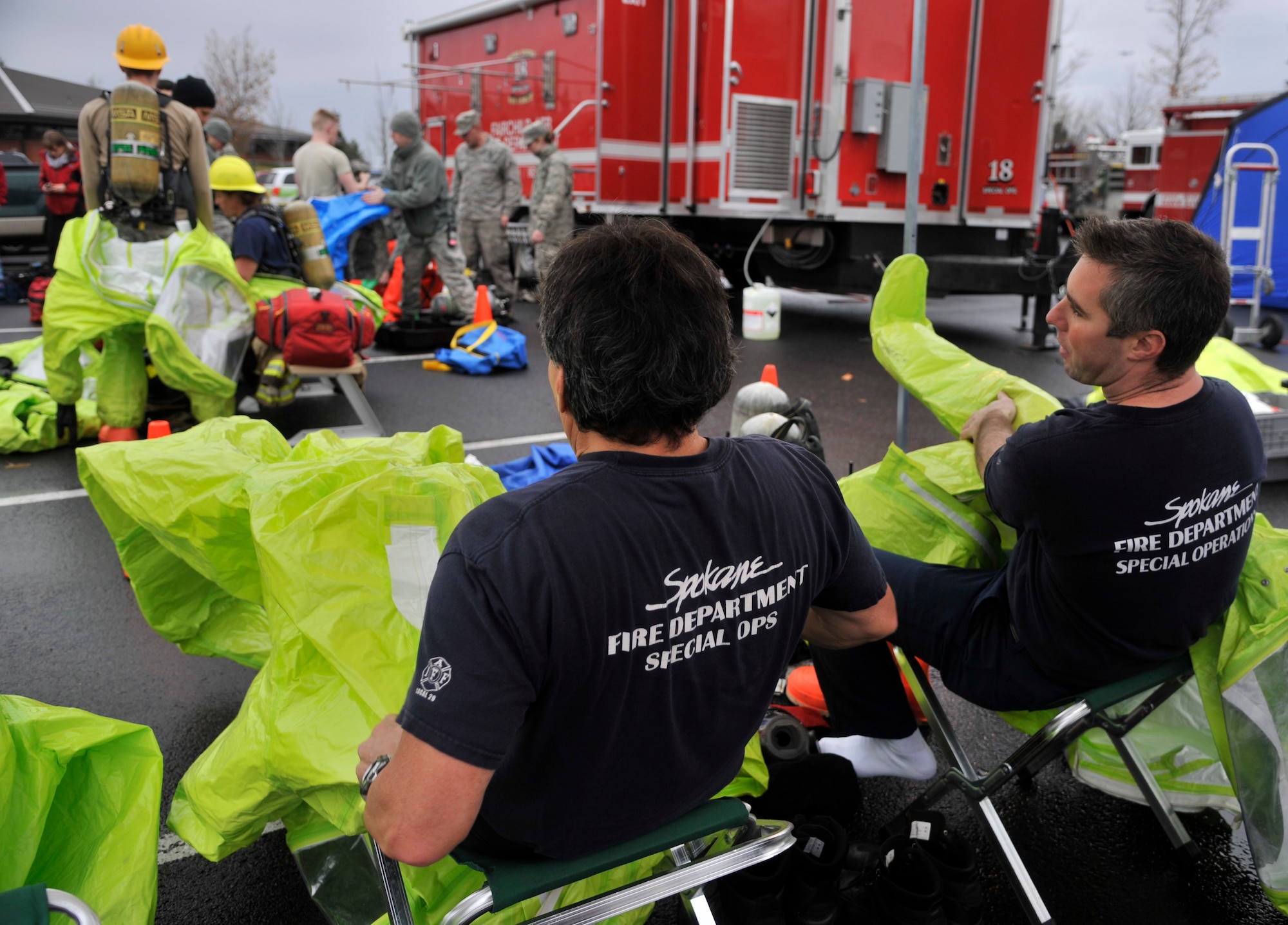 Members of the Spokane, Wash. fire department don personal protective equipment during a hazardous materials emergency response exercise Dec. 11, 2014, at Fairchild Air Force Base, Wash. During the four day exercise, Airmen and local Spokane, Wash. agencies came together to practice joint response efforts with around 40-60 different individuals involved per day. (U.S. Air Force photo/Senior Airman Mary O'Dell)