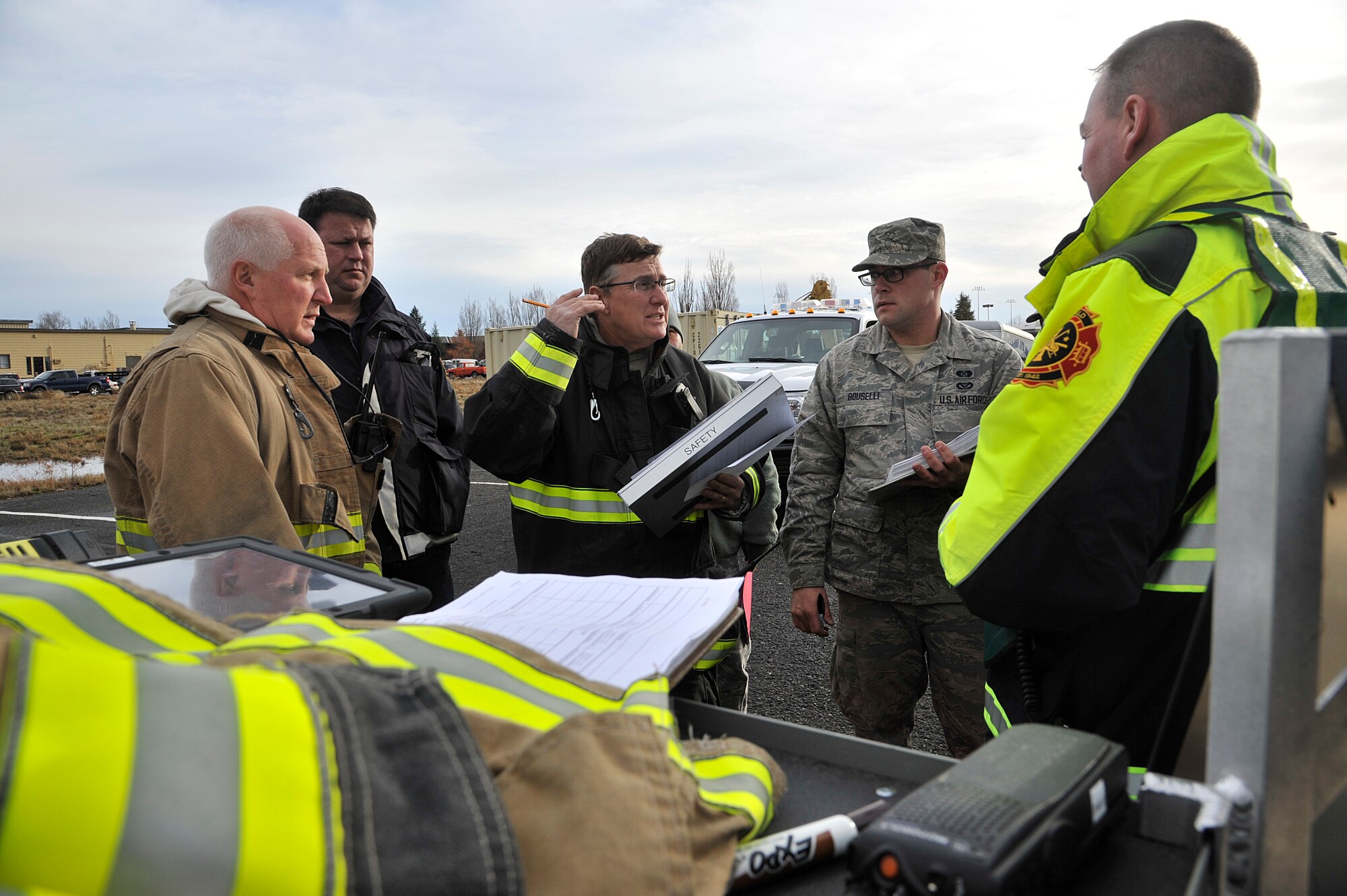 Members of the Spokane, Wash. fire department speak with Team Fairchild emergency responders during a hazardous materials emergency response exercise Dec. 10, 2014, at Fairchild Air Force Base, Wash. During the four day exercise, Airmen and local agencies came together to practice joint response efforts with around 40-60 different members involved per day. (U.S. Air Force photo/Senior Airman Mary O'Dell)