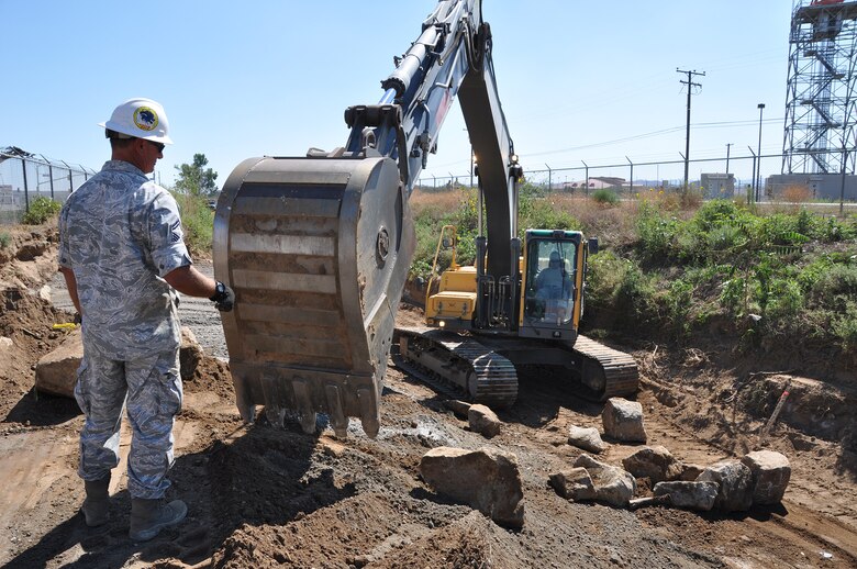 Senior Master Sgt. Robert Montgomery, heavy equipment superintendent, 163rd Civil Engineer Squadron, California Air National Guard, March Air Reserve Base, operates an excavator to move large rocks on the Heacock Channel project, Sept. 11, 2014. Reservists and Guardsmen from March participated in a joint-construction project to repair the erosion damage and sediment accumulation to the Heacock Channel on the east side of base. (U.S. Air Force photo/Senior Airman Russell S. McMillan)