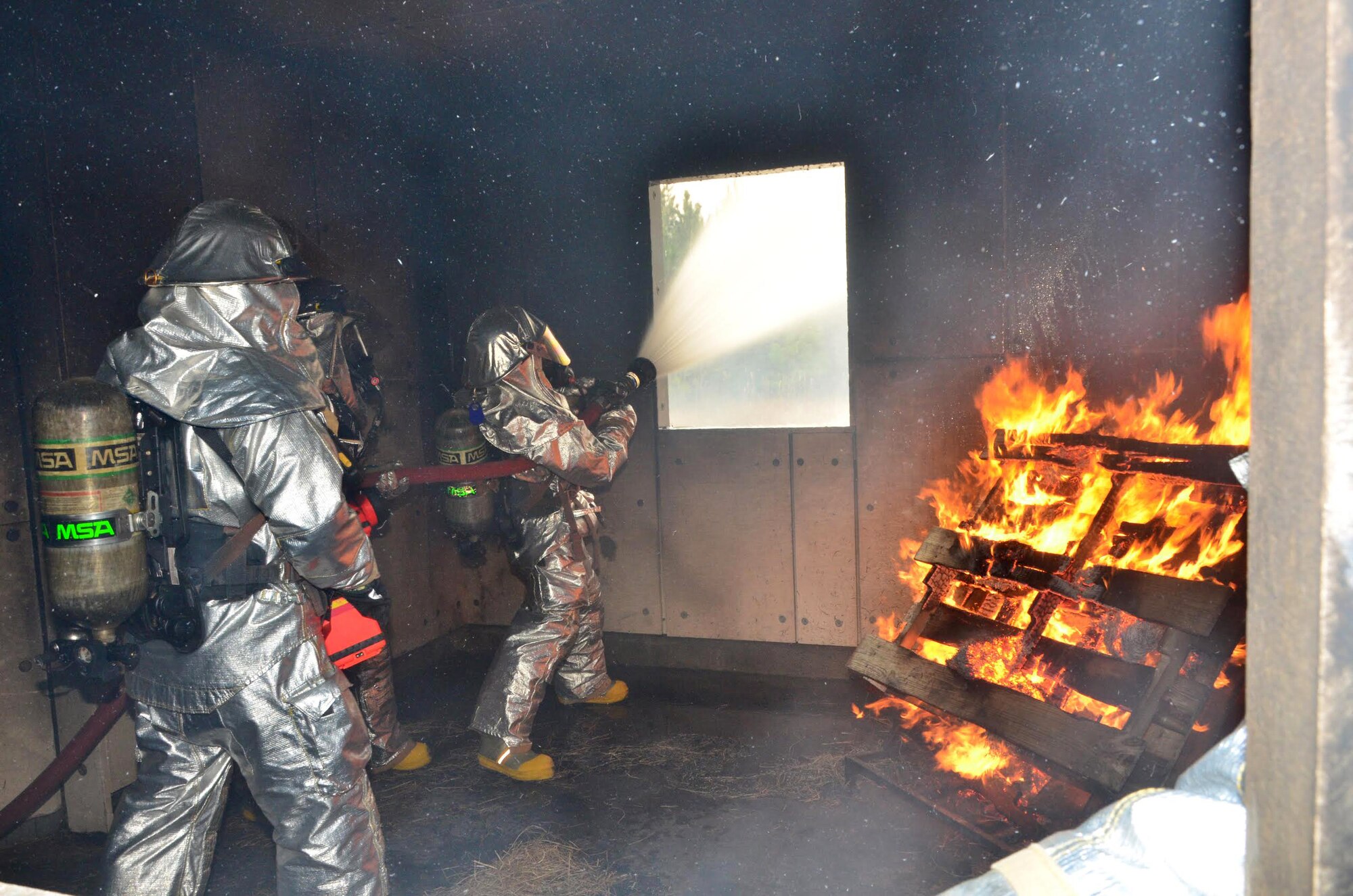 Senior Airman Shelby McGee, a reservist and firefighter with the 403rd Civil Engineering Squadron, Keesler Air Force Base, Mississippi, performs a hyrdraulic ventilation procedure to pull the smoke from the room during an annual structural fire exercise at the Gulfport International Airport Dec. 7, 2014 during the 403rd Wing Unit Training Assembly. (U.S. Air Force photo/Master Sgt. Brian Lamar)