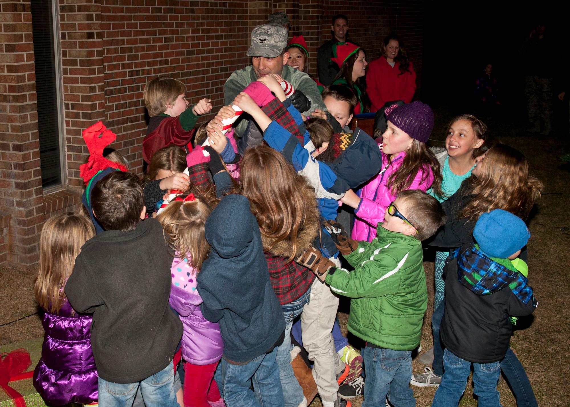 PETERSON AIR FORCE BASE, Colo. – Col. John Shaw, 21st Space Wing commander, gets help from children to pull the lever that turned on the lights decorating the Christmas tree at the base Chapel, Dec. 5. This year’s Christmas tree lighting was a family program where children lit a huge Christmas tree, made crafts, played games, iced cookies, met Santa Claus and received a toy. (U.S. Air Force photo by Airman 1st Class Rose Gudex)