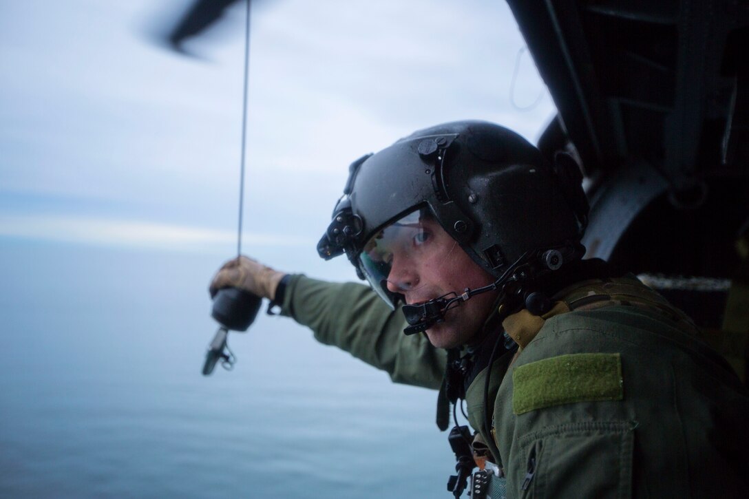 Dave Torrance, Tech. Sgt., 210th Rescue Squadron Special Mission Aviator with the Alaska Air National Guard’s HH-60 Pave Hawks, mans the hoist cable system during a training mission above Homer, Alaska. The cable hoist system is used to lower pararescuemen to treat and rescue potential victims when the weather or terrain does not allow for the helicopter to land. In a combat theater the hoist system allows for an expedited rescue to minimize the vulnerability of the Pave Hawk and the crew members. U.S. Air Guard photo by Lt. Bernie Kale.