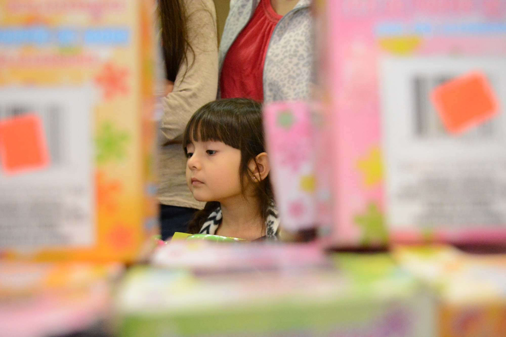 A child scopes out the toy selection during Operation Homefront Dec. 5 at Travis Air Force Base. The families that participated had more than 10,000 donated toys to choose from. (U.S. Air Force photo by Airman 1st Class Amber Carter)