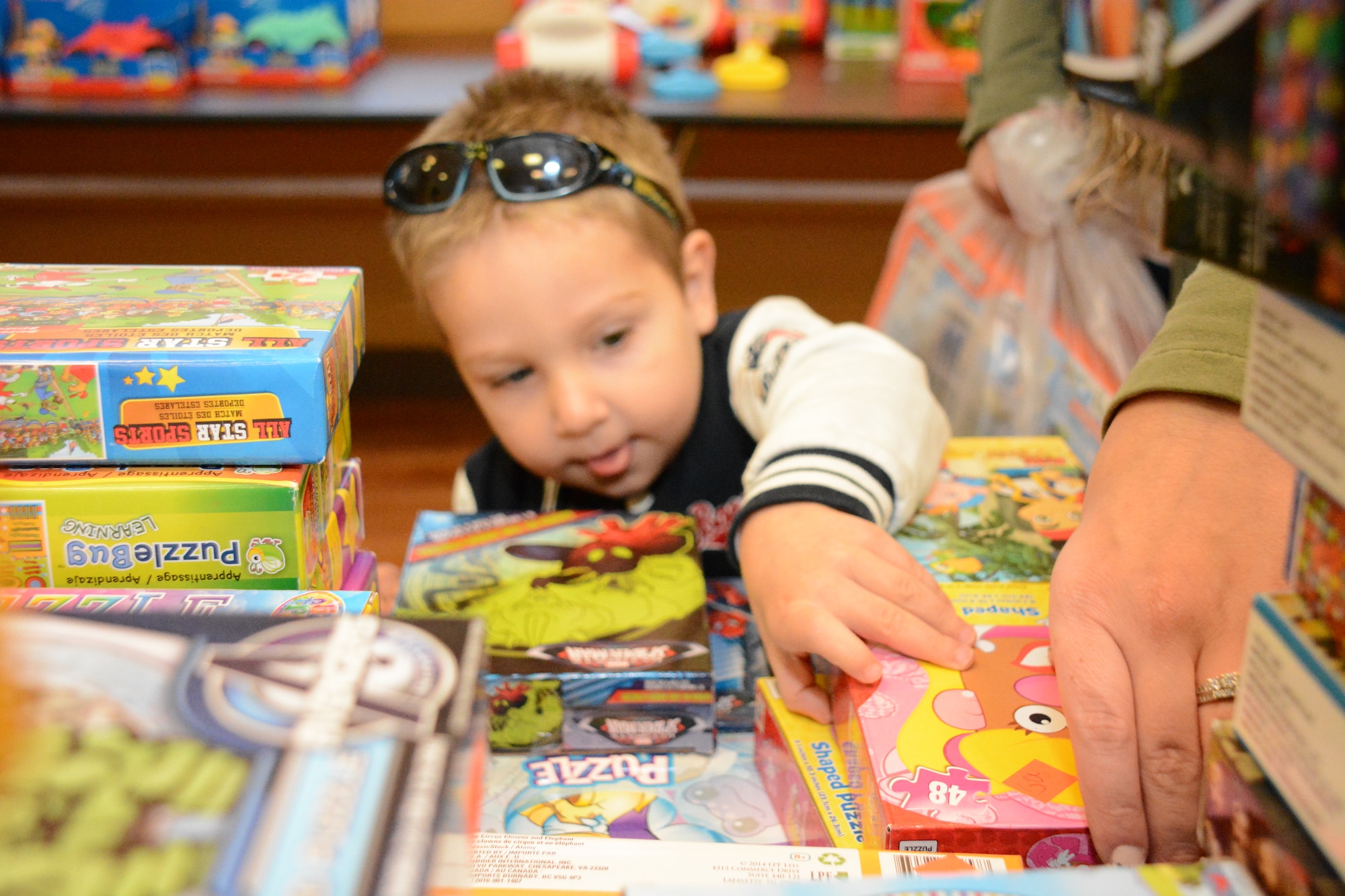 A child selects a toy during Operation Homefront Dec. 5 at Travis Air Force Base. More than 100 boxes of toys were donated from 10 discount stores in the local area. (U.S. Air Force photo by Airman 1st Class Amber Carter)