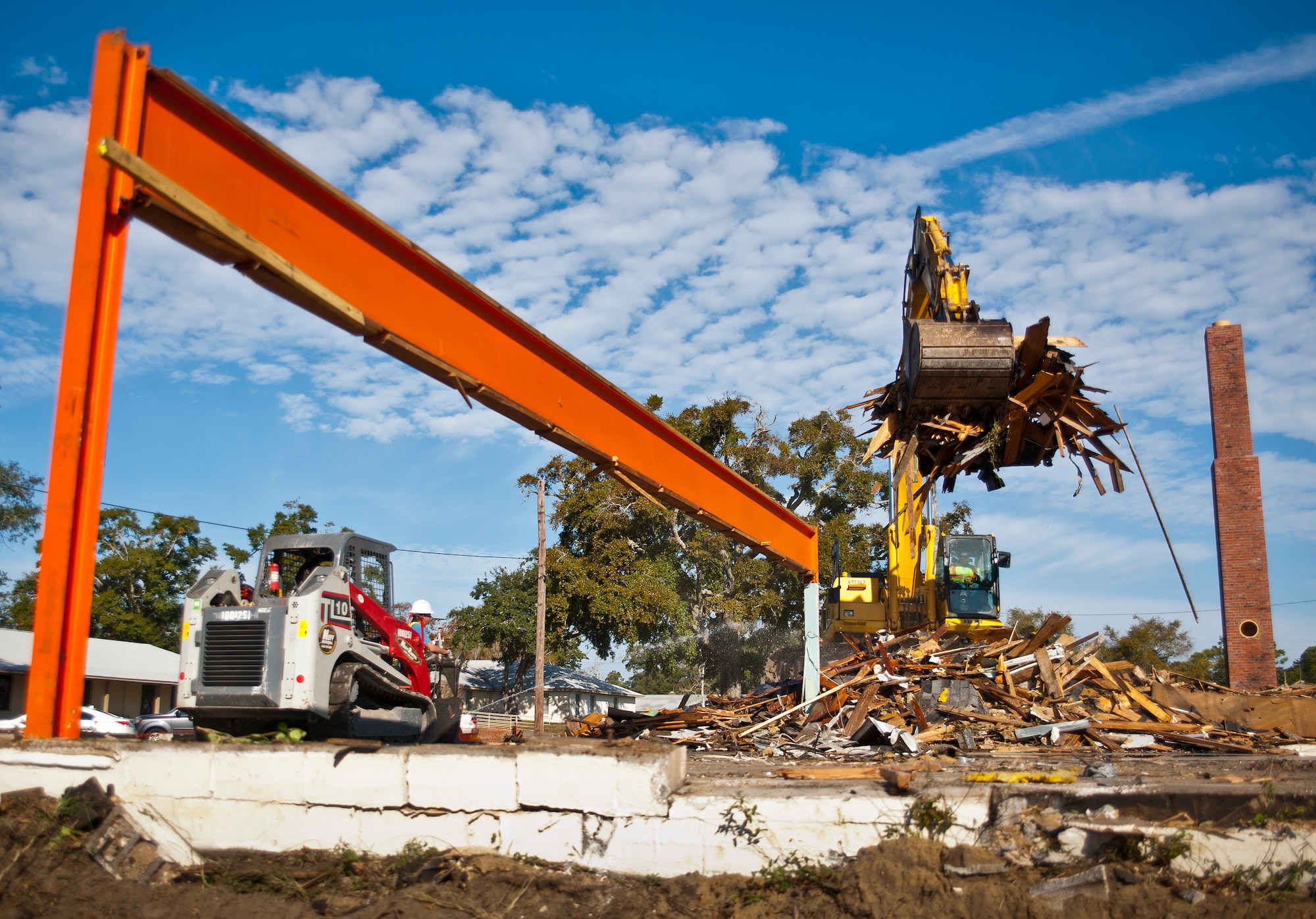 An excavator lifts up wood debris from what is left of Bldg. 223 Dec. 5 at Eglin Air Force Base, Fla.  The building was torn down as part of a cost-savings measure due to excess cost of updating and renovating the current structure.  (U.S. Air Force photo/Samuel King Jr.)