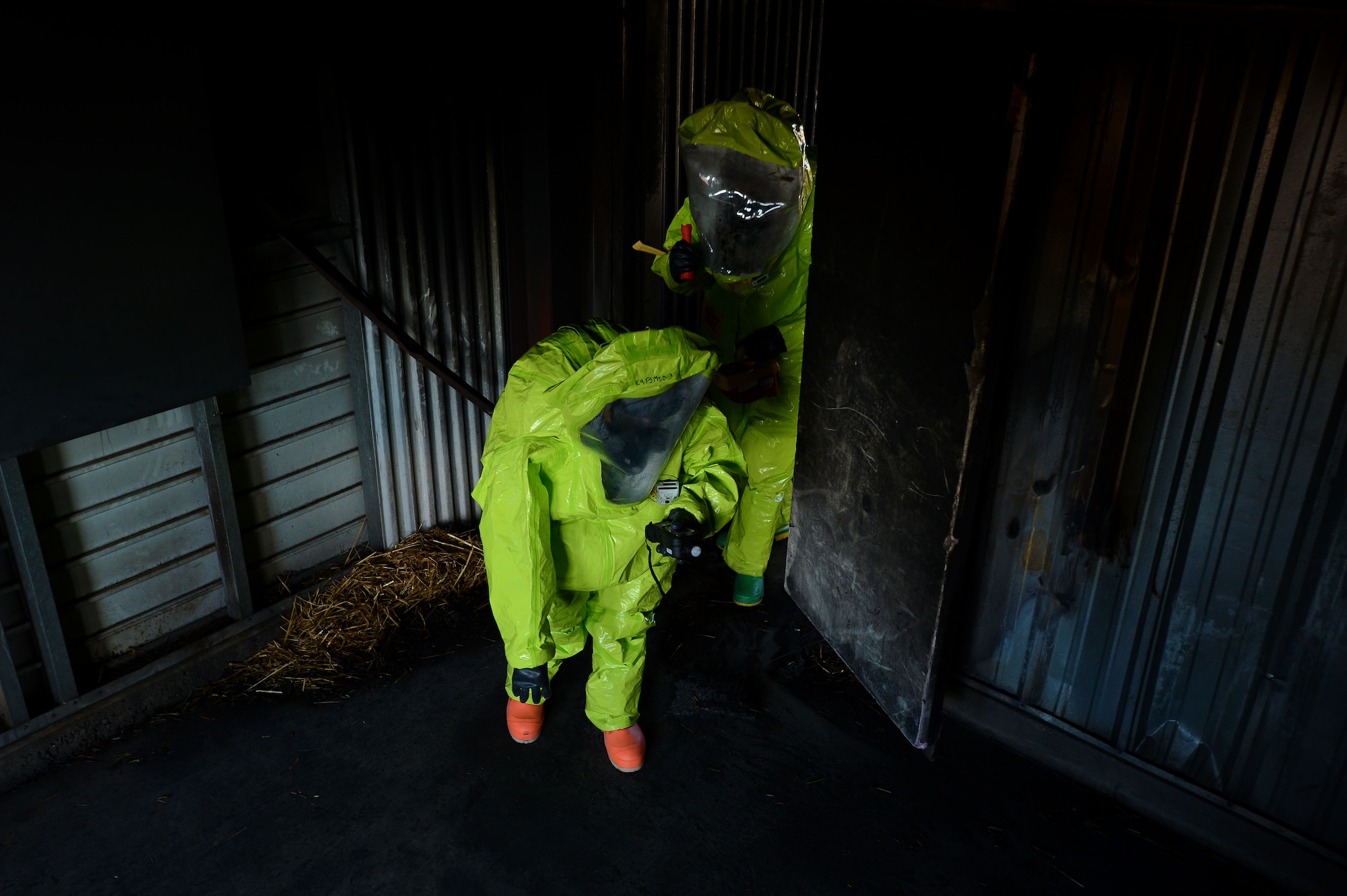 U.S. Air Force Senior Airman Chantal Hogue, 20th Civil Engineer Squadron emergency management apprentice, and Senior Airman Brandon Burgess, 20th Aerospace Medicine Squadron bioenvironmental engineering journeyman, search for a simulated chemical agent during an integrated base emergency response capability training exercise at Shaw Air Force Base, S.C., Dec. 10, 2014. After the two verified the found chemicals, they radioed their emergency response team to seek handling instructions. (U.S. Air Force photo by Airman 1st Class Jensen Stidham/Released)