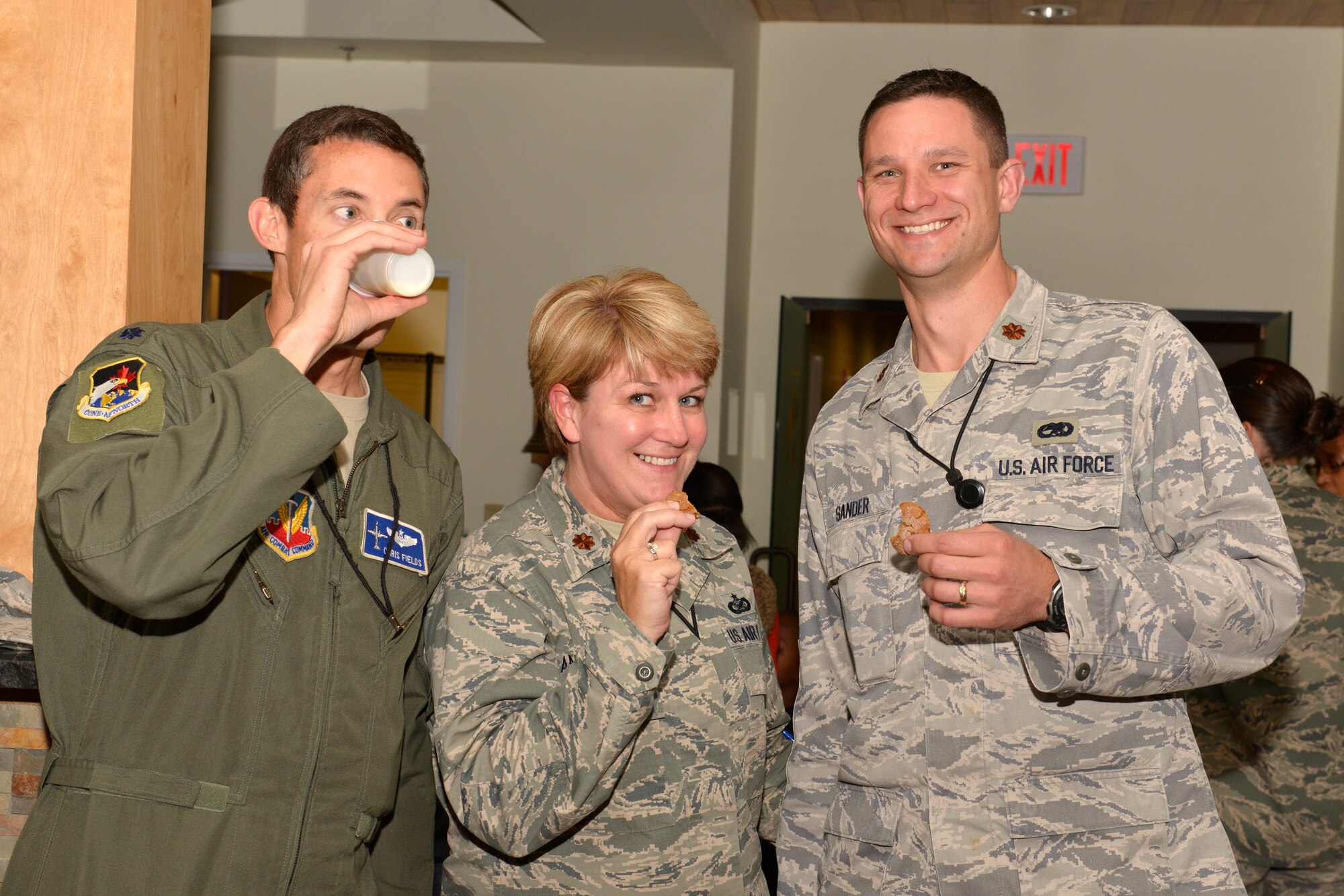 TYNDALL AIR FORCE BASE, Fla. – Lt. Col. Christopher Fields, (From left), Maj. Katrina Andrews, Maj. Jason Sander, partake in cookies and refreshments as part of the annual tree-lighting ceremony held at Air Forces Northern Tuesday inside the Killey Center for Homeland Operations. (U.S. Air Force Photo by Master Sgt. Kurt Skoglund/Released)


