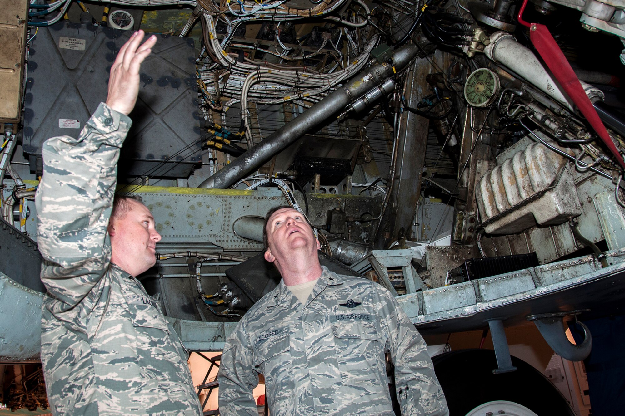 U.S. Air Force Tech. Sgt. Walther Lachney, 307th Maintenance Squadron technician, explains the phase process of a B-52H Stratofortress to Brig. Gen. Richard Scobee, 10th Air Force commander, during a tour on Dec. 6, 2014, Barksdale Air Force Base, La. Lachney explained the process is essentially an overhaul of the plane in which every system of the jet is thoroughly examined and maintained. Scobee presented Lachney with a 10th AF coin for his role in cutting operational check time on the B-52 and winning the 307th Aircraft Maintenance Squadron Maintenance Technician of the Year.  (U.S. Air Force photo by Tech. Sgt. Ted Daigle/ released)