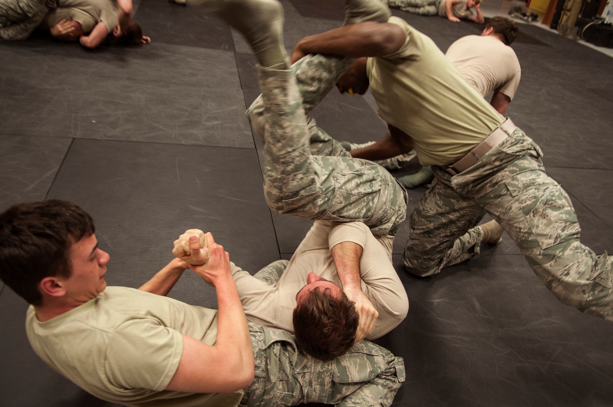 Members of the 823d Base Defense Squadron perform two-on-one grappling during their annual security forces combatives training Dec. 9, 2014, at Moody Air Force Base, Ga. All security forces members learn self-defense combat and are trained to use less-than-lethal force when possible. (U.S. Air Force photo by Senior Airman Sandra Marrero/Released)
