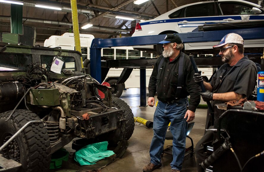 Gary Kaylor, 5th Logistics Readiness Squadron superintendent of general purpose allied trade, (left) speaks with Melbourne Millsap, 5th LRS contractor, (right) regarding maintenance on a humvee in the 5th LRS maintenance bay on Minot Air Force Base, N.D., Dec. 2, 2014. An average of 20 vehicles are in Kaylor’s shop undergoing maintenance every day. (U.S. Air Force photo/Senior Airman Stephanie Morris)