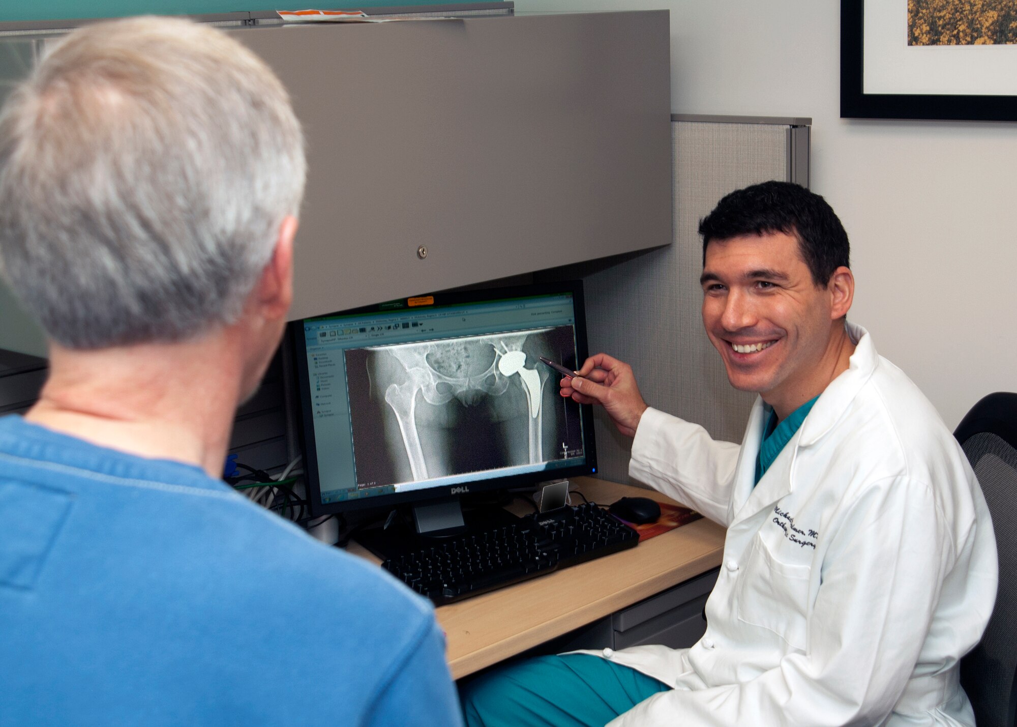 Maj. (Dr.) Michael Palmer, 2014 recipient of the Braxton Award by the Fisher House at Wright-Patterson Air Force Base, speaks with a patient about X-rays. (Air Force photo by Mark Pugel, 88th Medical Group)