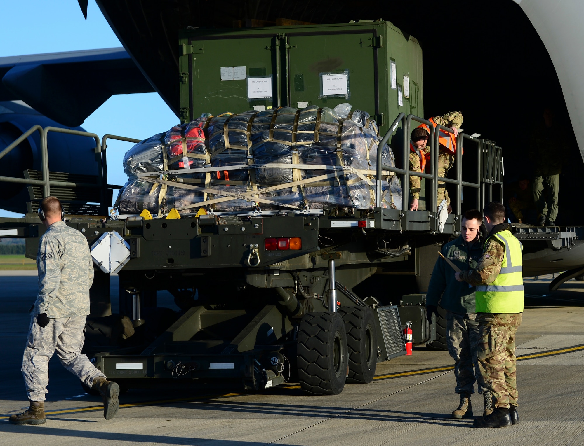 Royal Army and U.S. Air Force personnel load cargo onto a Royal Air Force C-17A Globemaster III, Dec. 3, 2014 at Royal Air Force Lakenheath, England. The Movement Coordination Centre Europe program was established in 2007 recognizing shortages of Strategic Lift. (U.S. Air Force photo by Airman 1st Class Dawn M. Weber/Released) 