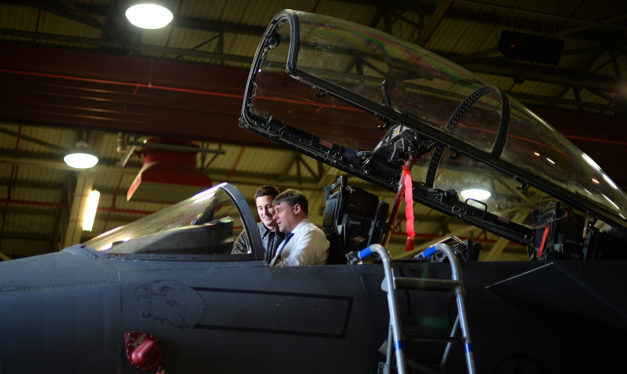 Capt. Eric Straub, 492nd Fighter Squadron pilot, shows the Right Honourable Mark Francois, Minister of State for the Armed Forces, the cockpit of an F-15E Strike Eagle during a tour of the 48th Fighter Wing at Royal Air Force Lakenheath, England, Dec. 11, 2014. Inviting key members from the local community, such as Francois, helps elevate community relations and increase understanding of the 48th FW’s mission to provide worldwide response combat airpower and support to meet our nation’s objectives. (U.S. Air Force photos by Staff Sgt. Emerson Nuñez/Released)