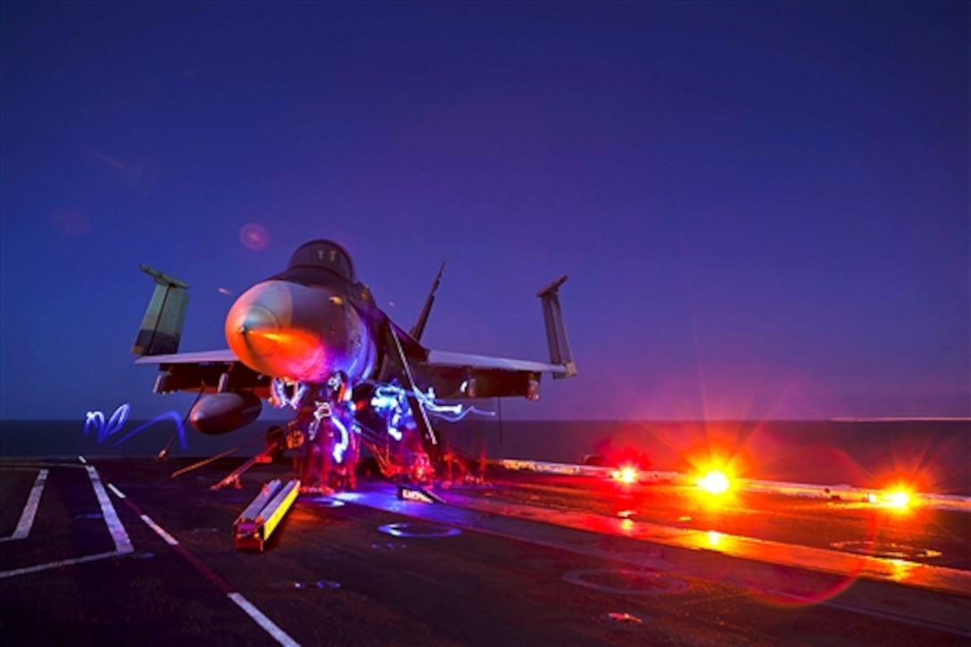 U.S. Navy sailors perform maintenance on an F/A-18C Hornet on the flight deck of the aircraft carrier USS Carl Vinson in the Persian Gulf, Dec. 5, 2014. The carrier is supporting strike operations in Iraq and Syria as directed, maritime security operations, and theater security cooperation efforts in the region. 