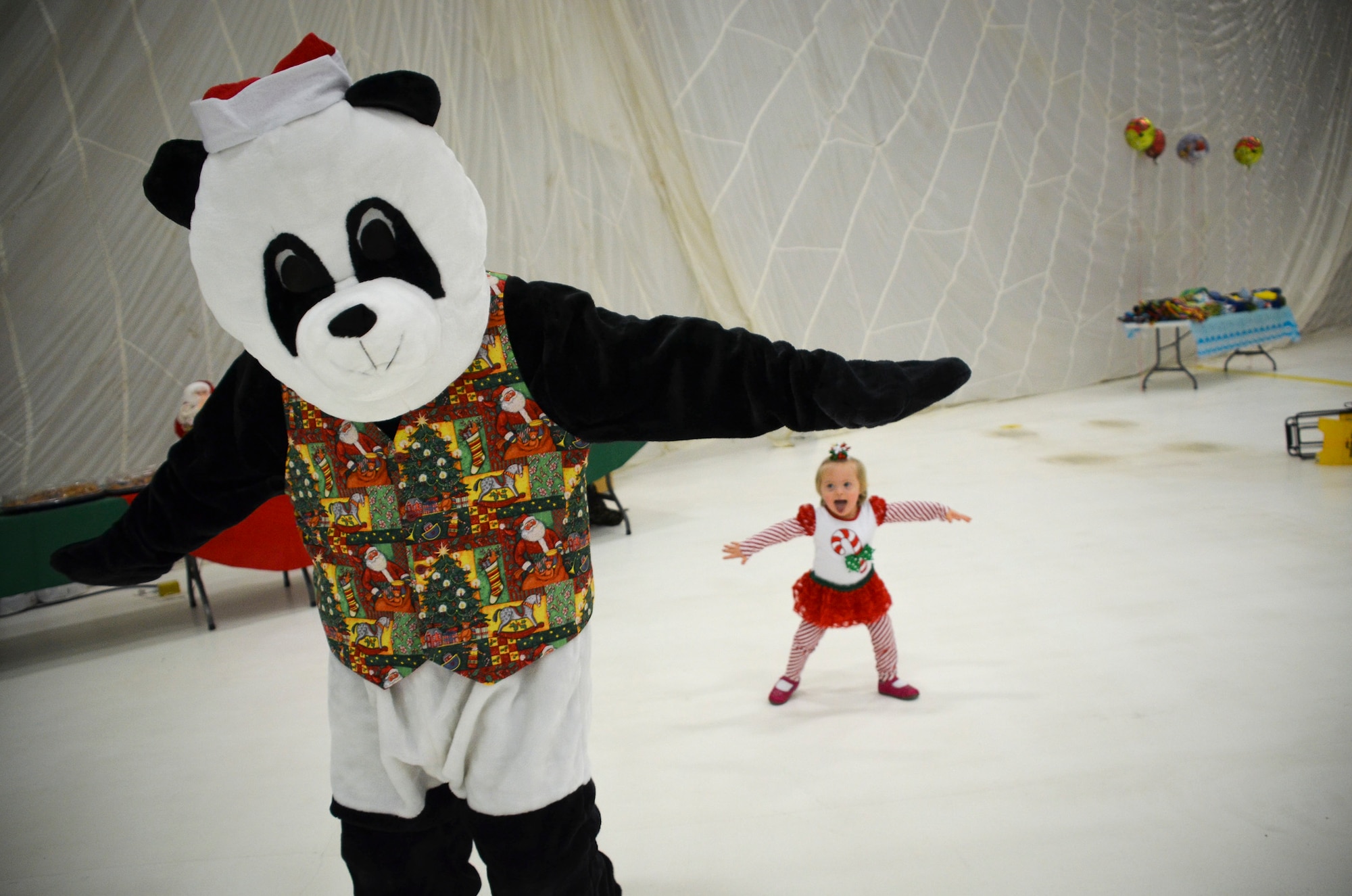Katherine Mosses, 3, dances with a panda bear as she waits to see Santa Claus.  The annual Flight to the North Pole is hosted by the 128th Air Refueling Wing, Wisconsin Air National Guard, Milwaukee Dec. 13, 2014 here.  (U.S. Air National Guard photo by Master Sgt. Thomas J. Sobczyk/Released)