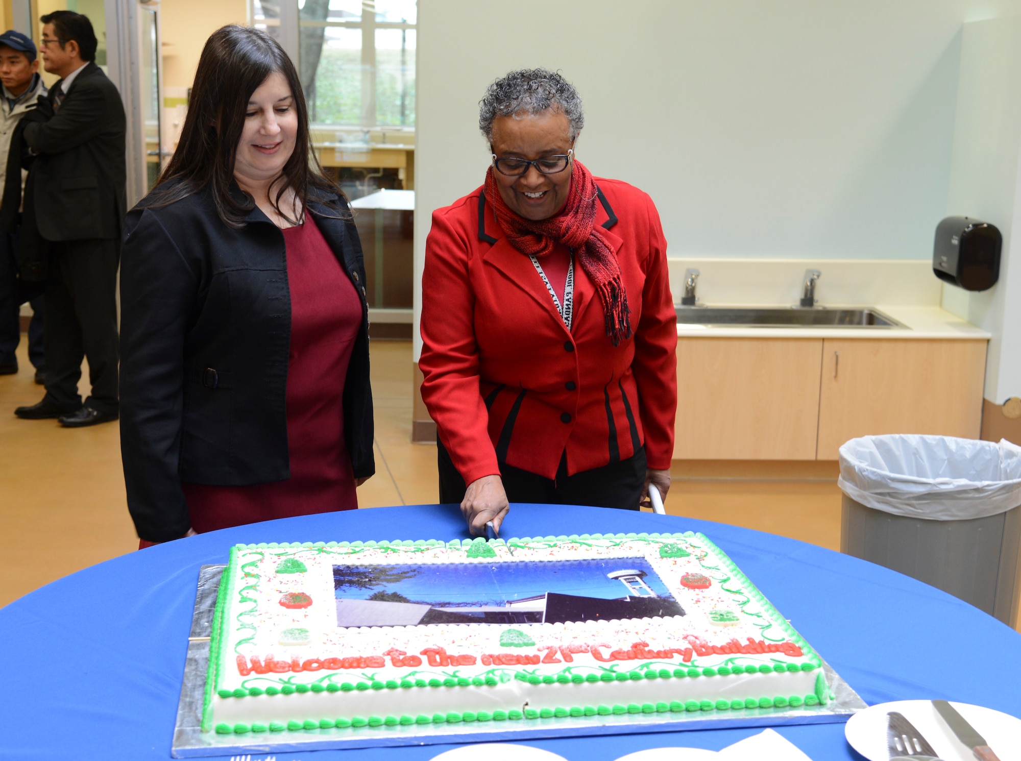 Mrs. Hattie Phipps, Joan K. Mendel Elementary School principal, (right) and Mrs. Teresa Moon, Joan K. Mendel Elementary School assistant principal, cut the cake after the ribbon cutting ceremony for a new Kindergarten building at Yokota Air Base, Japan, Dec. 12, 2014. The new building will be used for Kindergarten and special needs kids. (U.S. Air Force photo by Senior Airman Michael Washburn/Released)